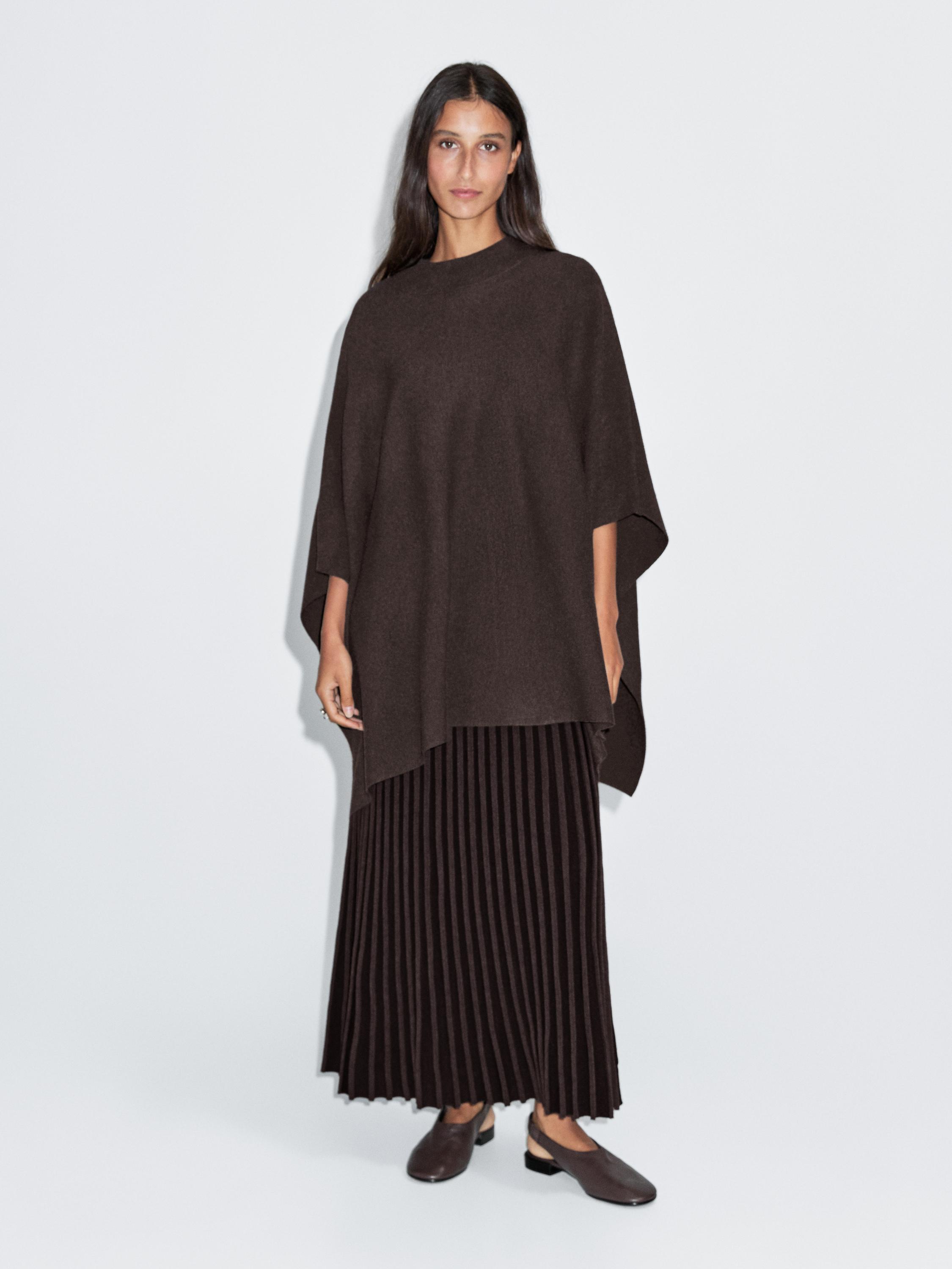 Brown knitted cape set with high neck and long brown pleated skirt.