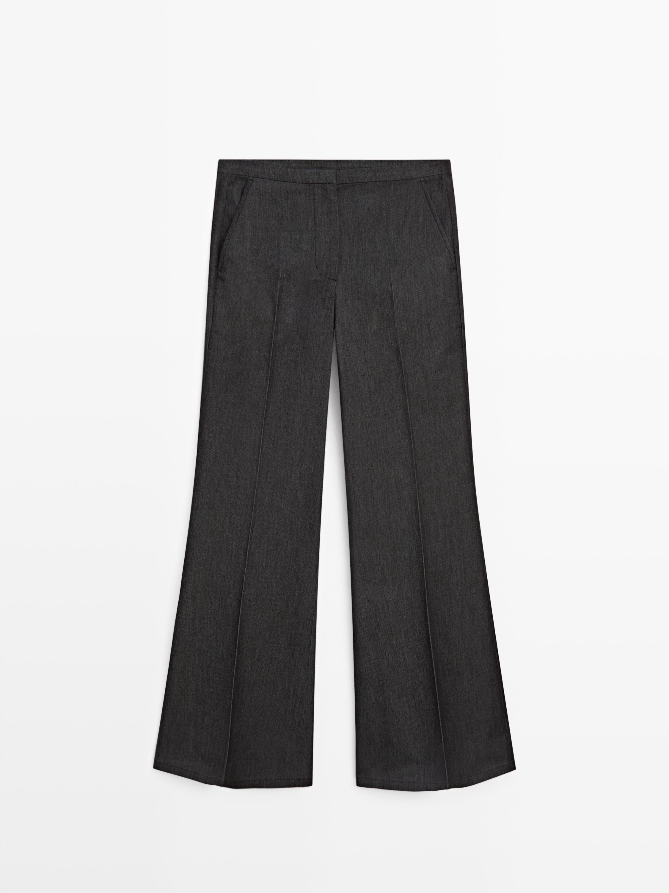 Vista frontal de pantaló negre flare fit amb butxaques laterals i plecs marcats.