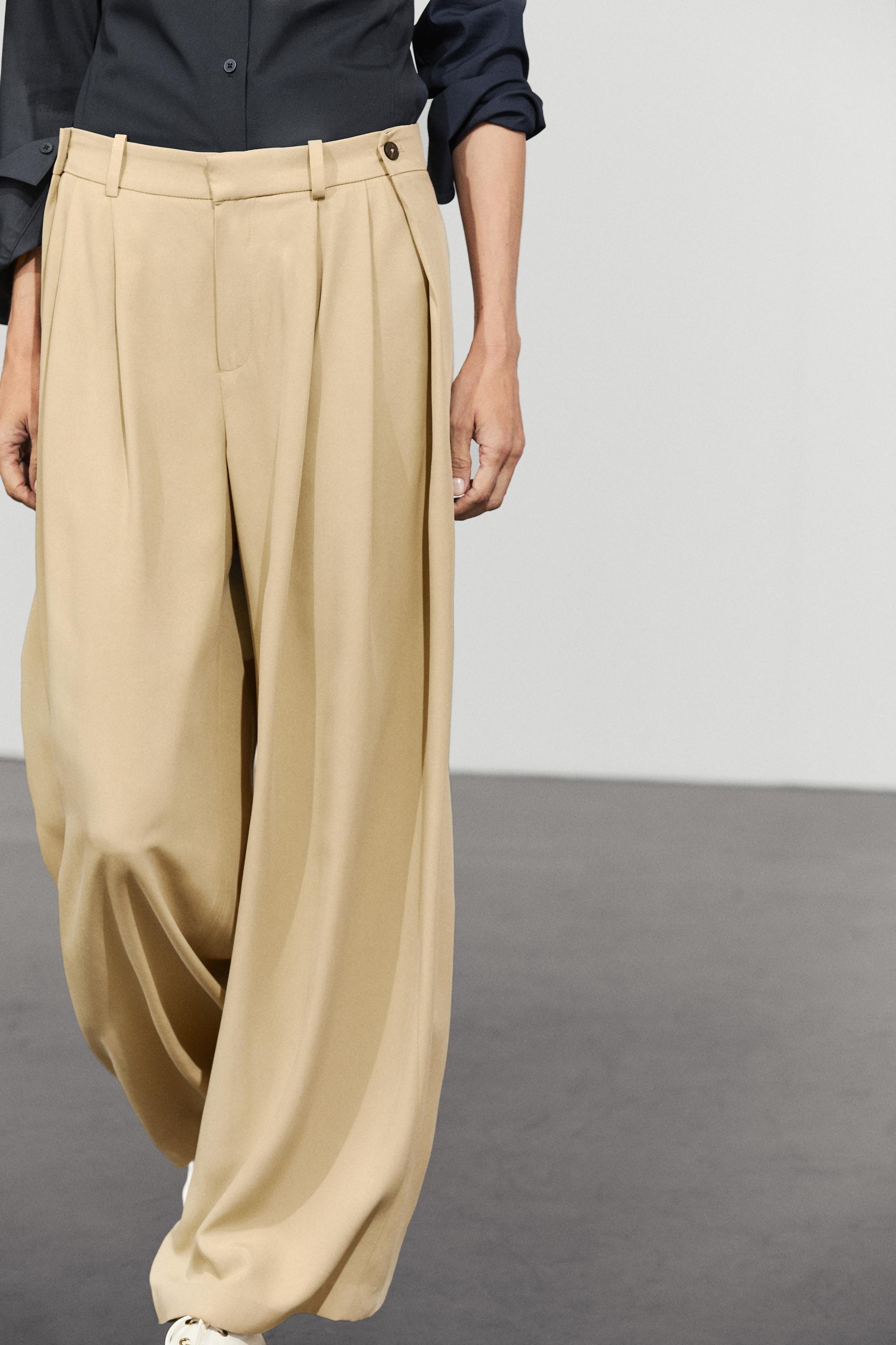 Flowing pleated pants with button detail