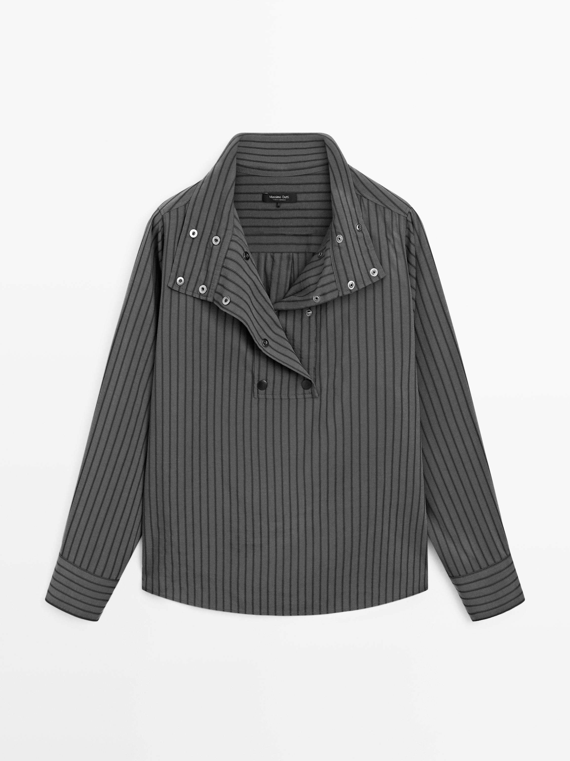 Vue de face d'une chemise grise rayée avec un col large et des boutons décoratifs.