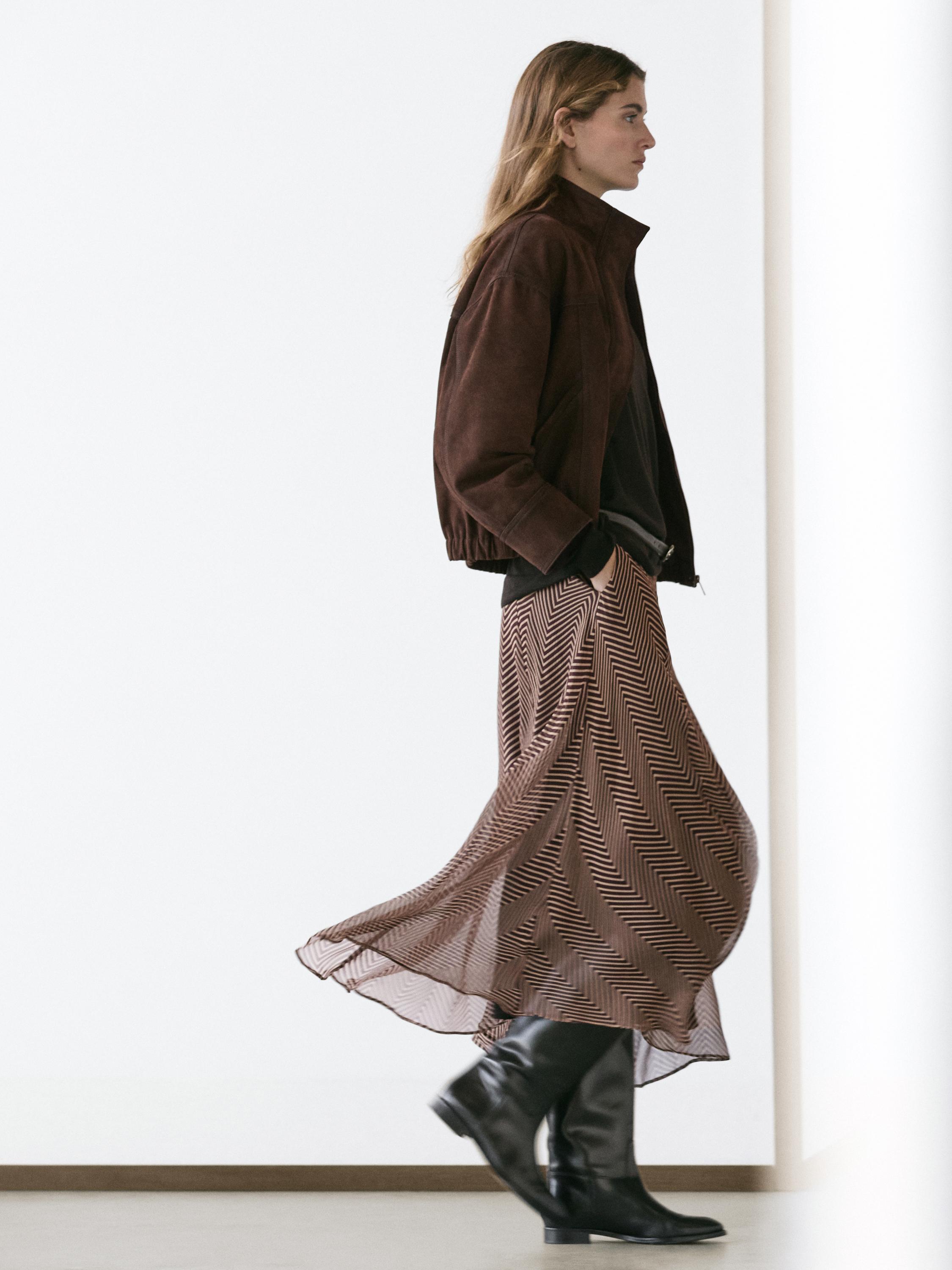 Komplet xhakete ngjyrë vishnje, fund-pantallona të shkurtra me print ngjyrë vishnje dhe të zezë, dhe çizme të zeza.