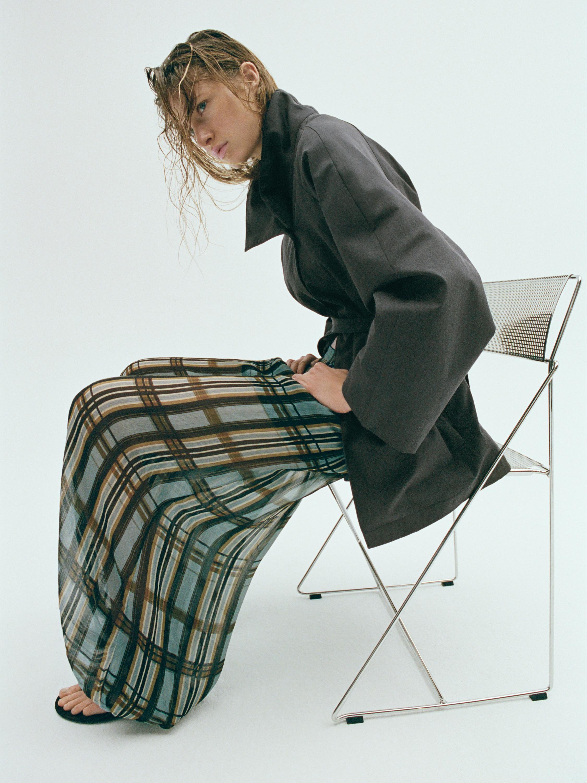 Conjunt d'abric fosc i pantalons bombatxos blau clar amb estampat de quadres.