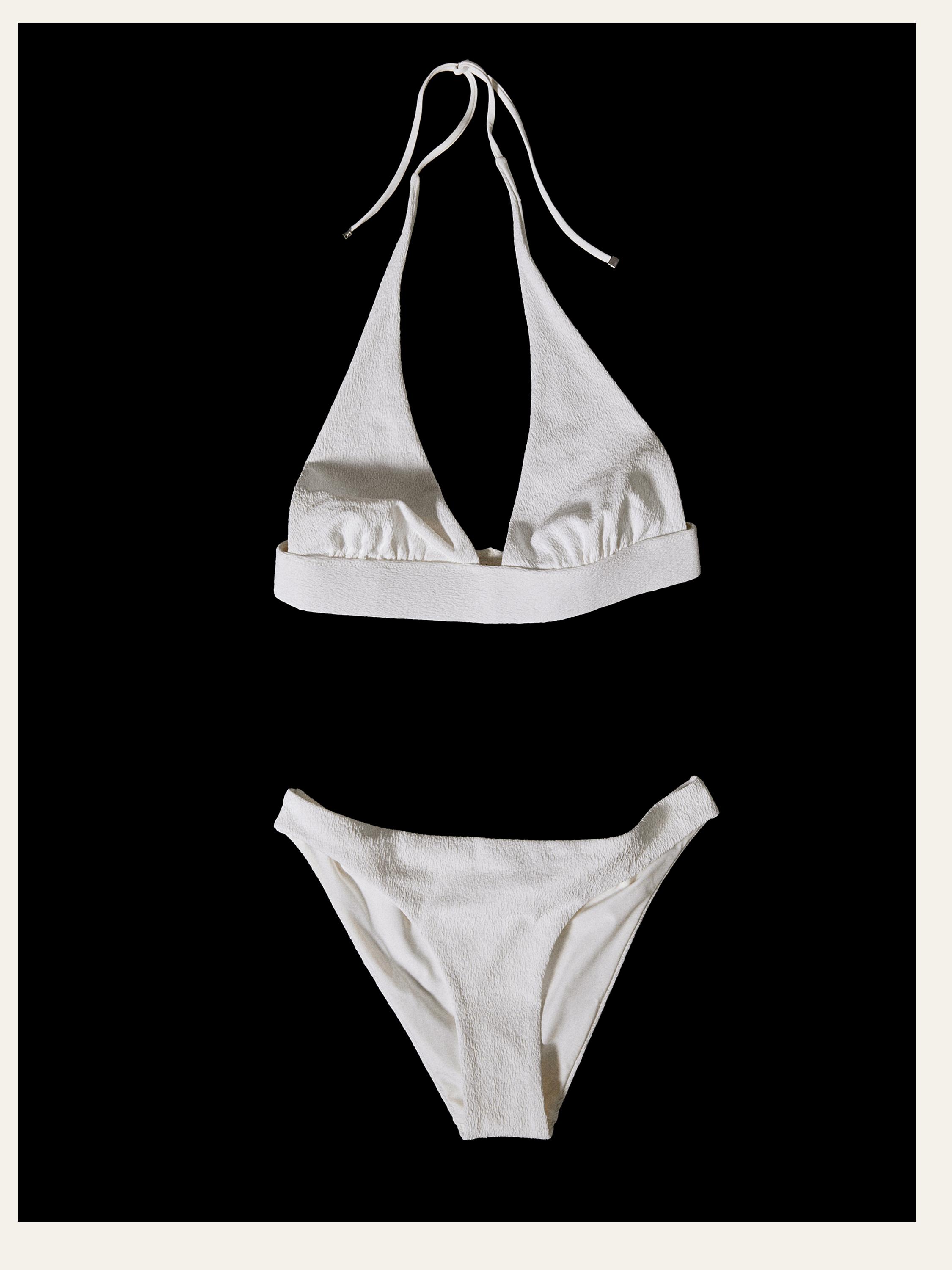 Vista frontal de bikini blanco con top de triángulo y tiras al cuello, y braguita de corte clásico.