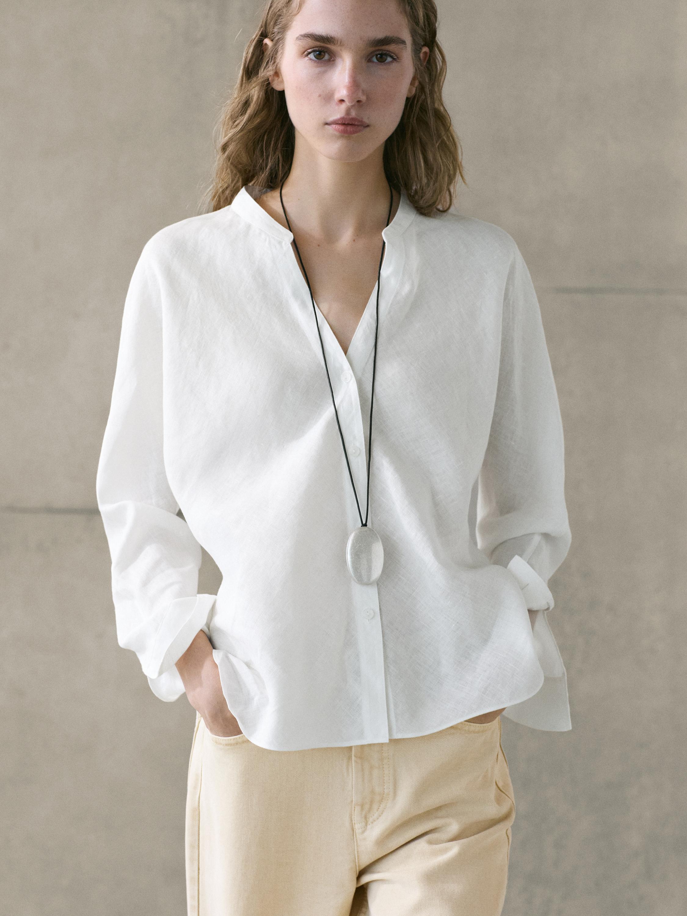 Conjunto de camisa blanca de cuello mao y pantalones beige con bolsillos laterales.