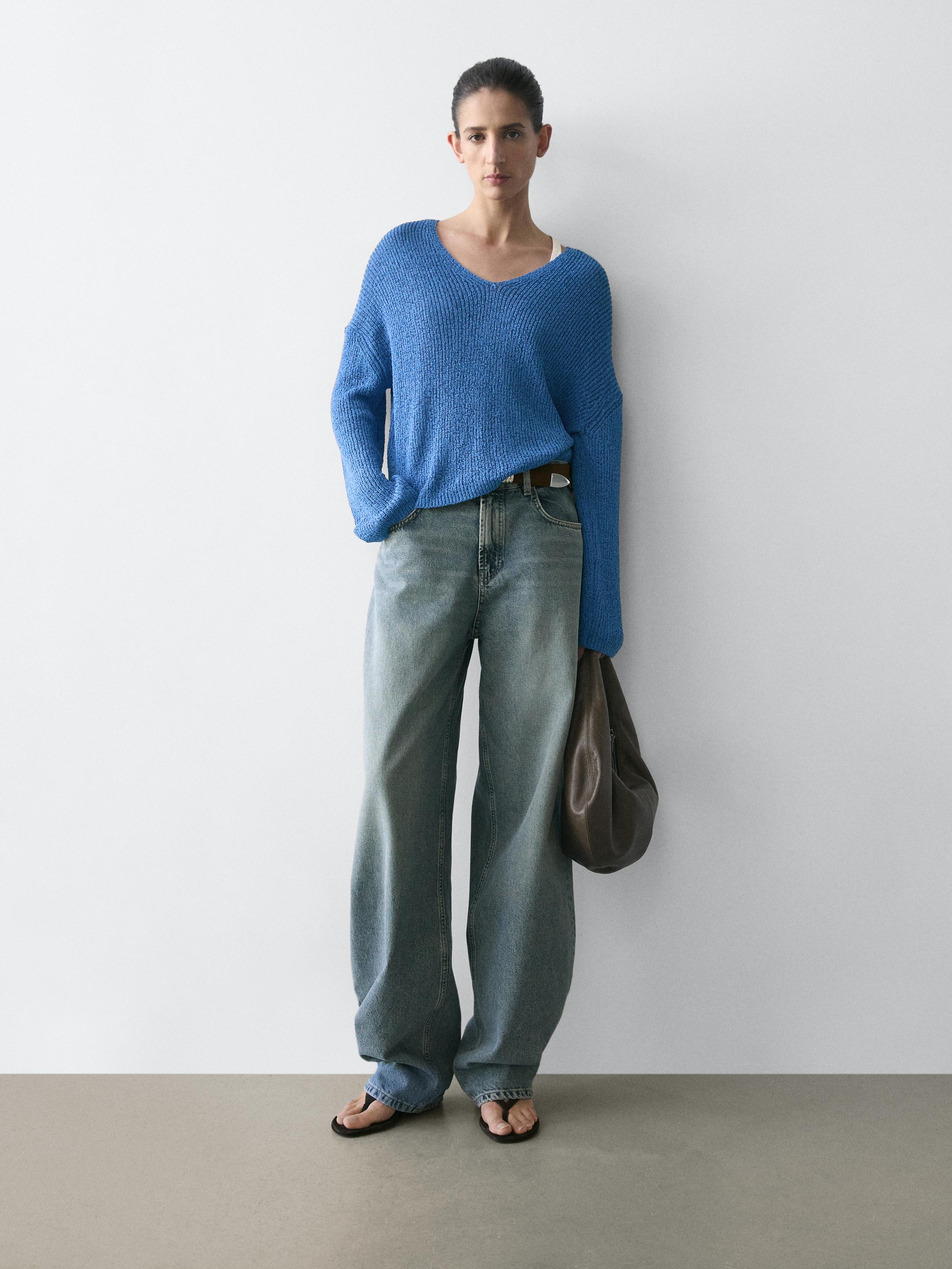Conjunto de suéter azulina de punto con cuello en V y jeans anchos.
