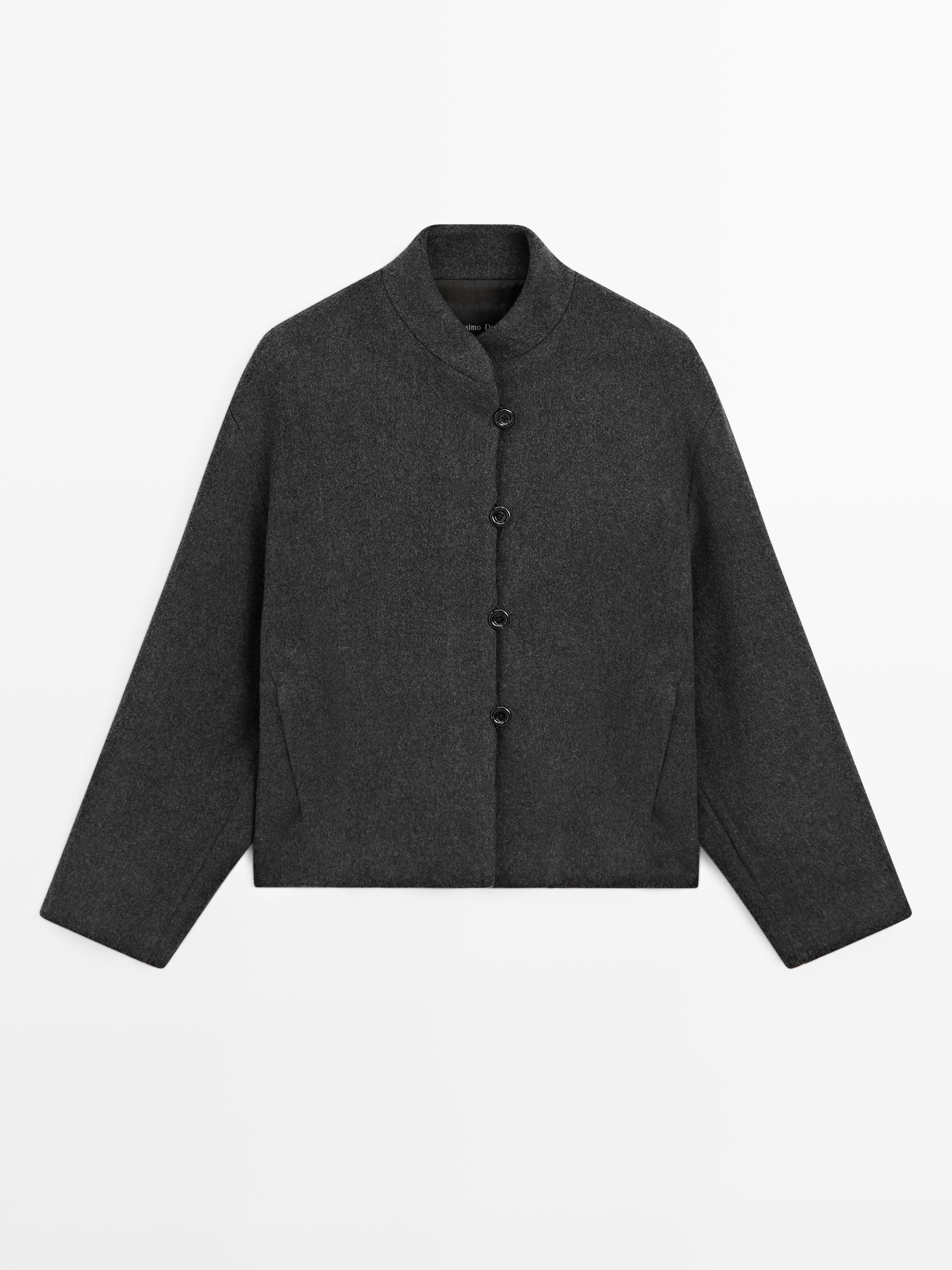 Sprednji pogled sivega plašča z mao ovratnikom, s sredinskim zapenjanjem in stranskimi žepi.