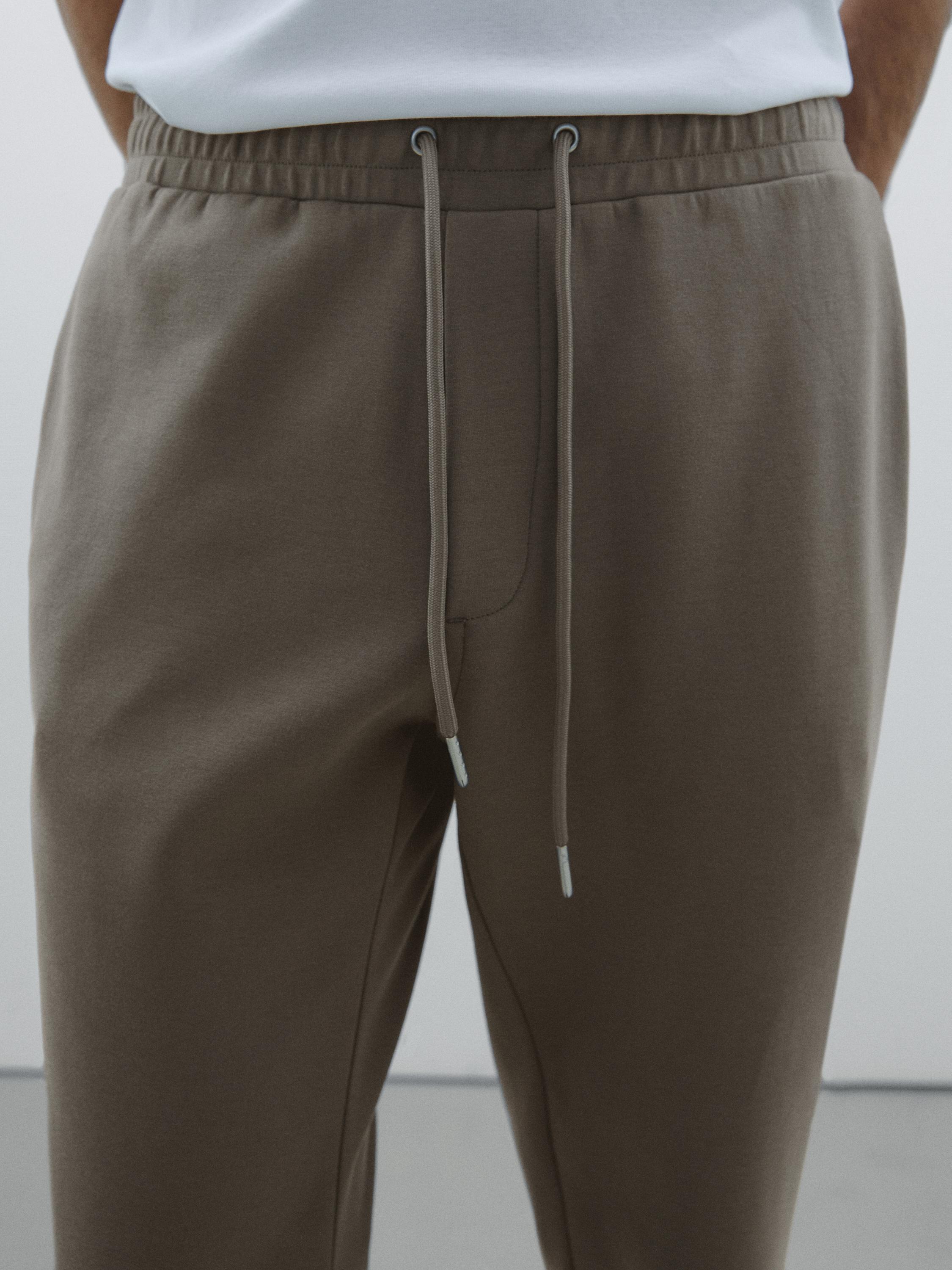 Détail du pantalon marron avec cordon de serrage à la taille