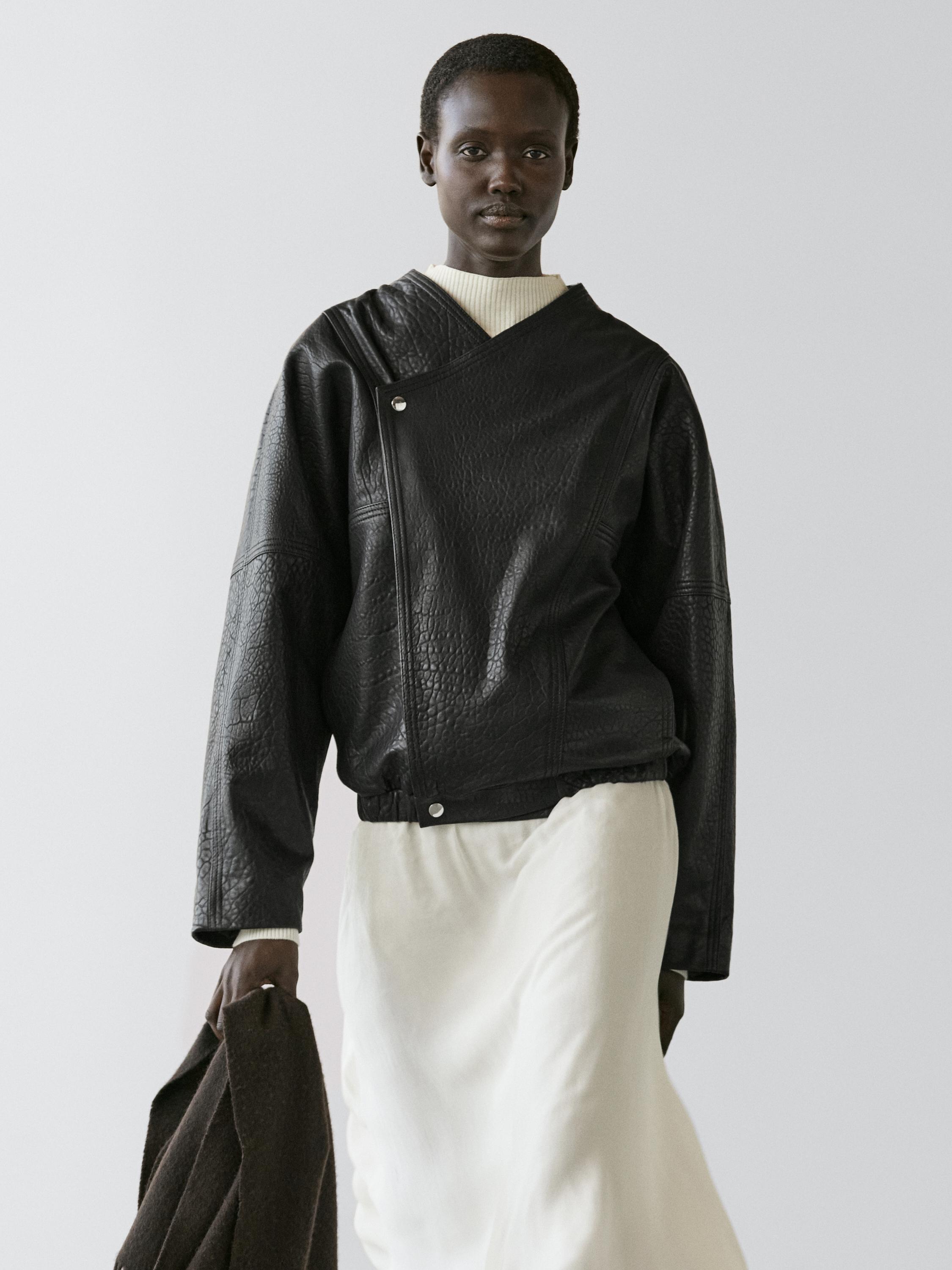 Ensemble bomber noir avec fermeture asymétrique et jupe longue blanche.