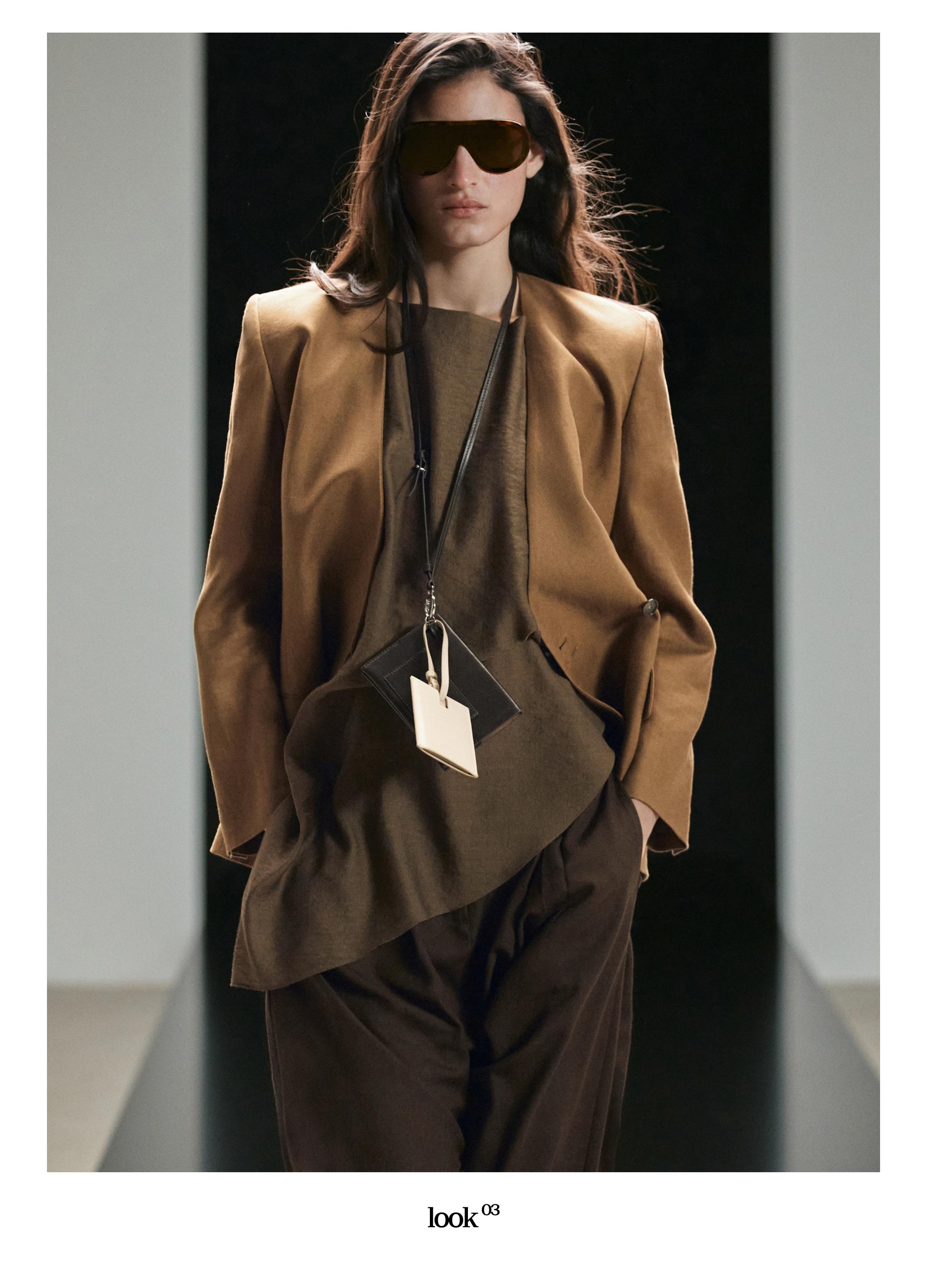 Conjunto de blazer café claro y pantalón café oscuro, con camiseta café y lentes de sol grandes.