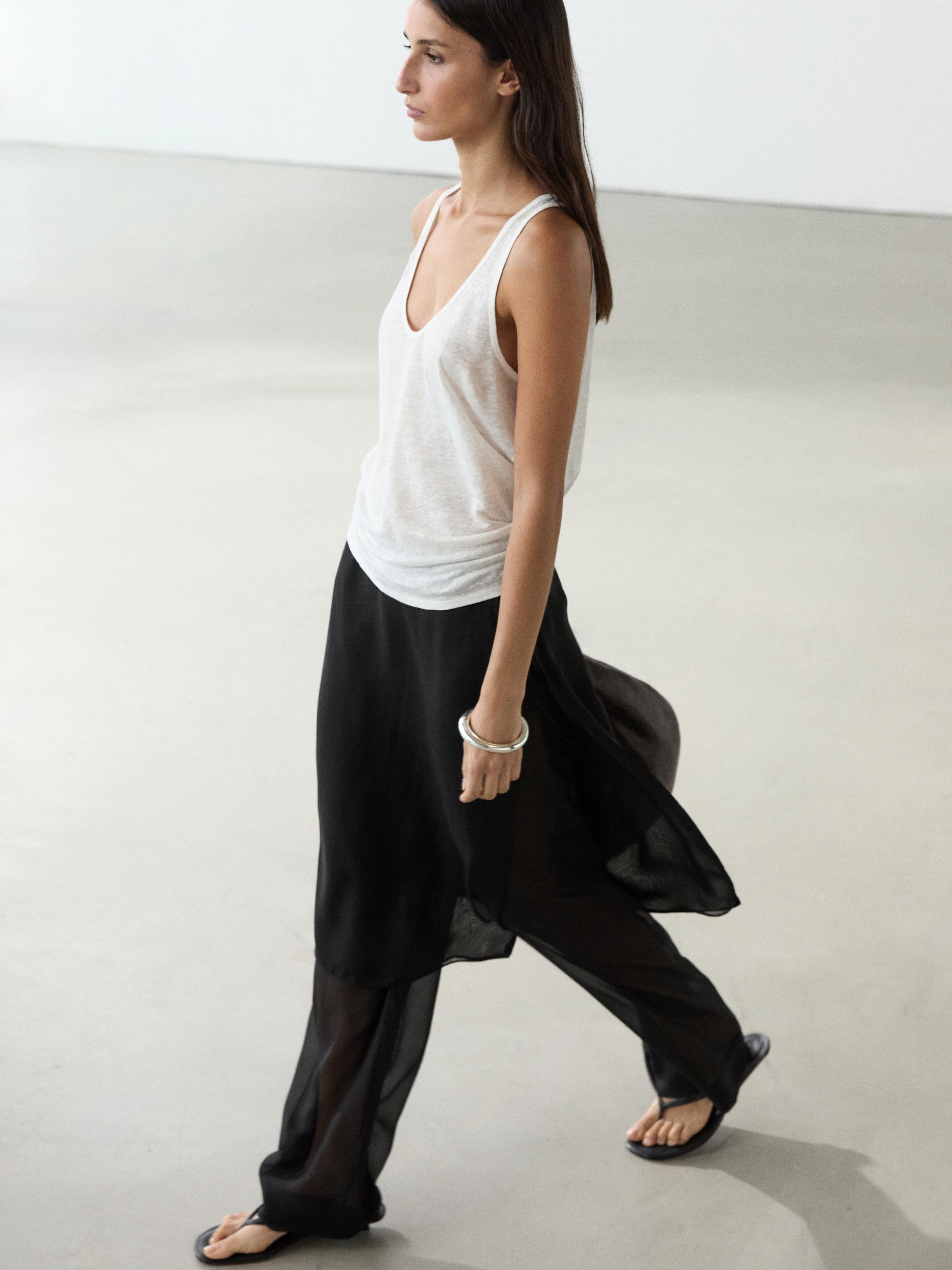 Zwarte lange broekrok en witte mouwloze top set.