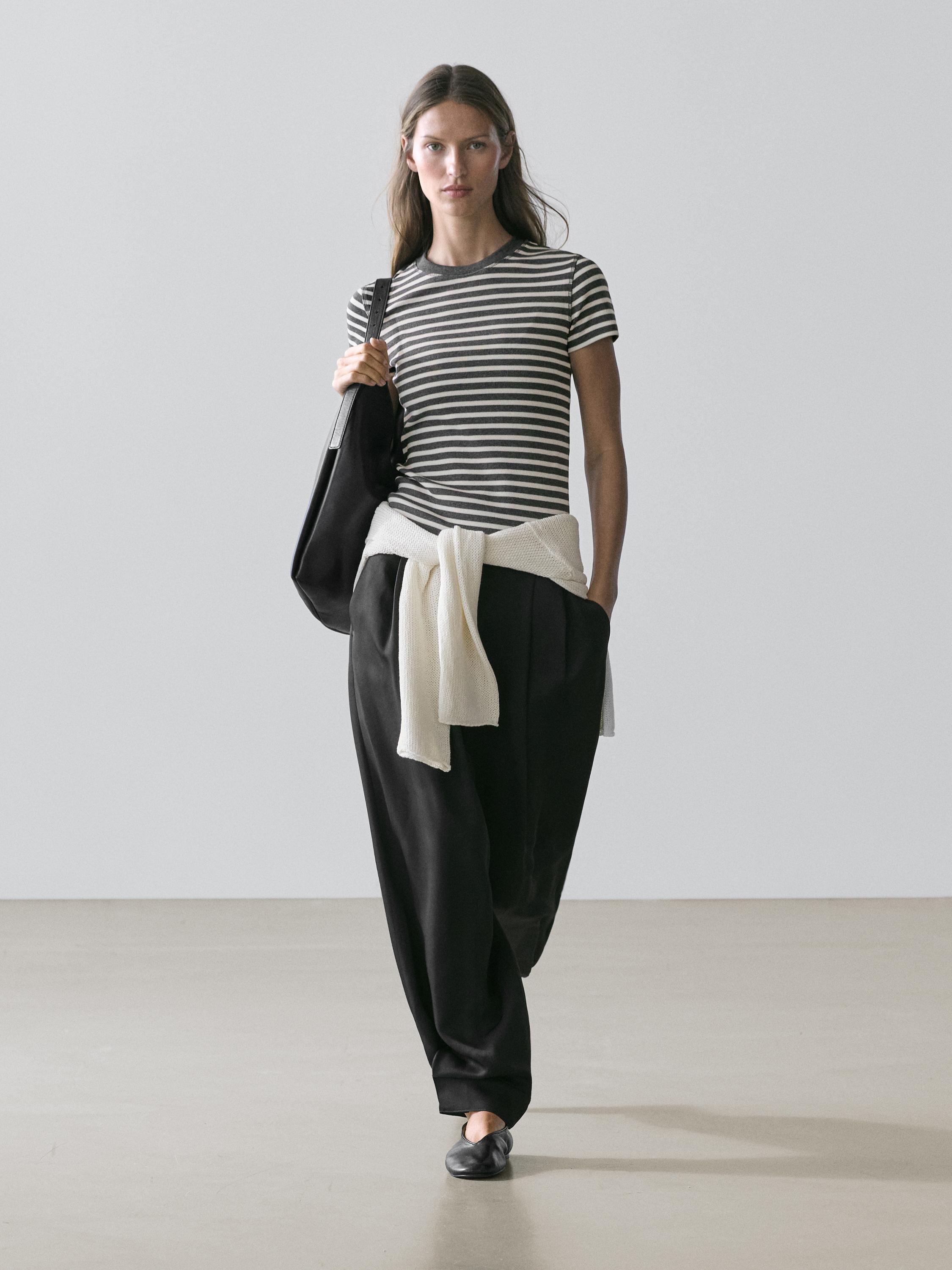 Gray striped short-sleeve t-shirt set, wide black pants, white sweater tied at the waist.