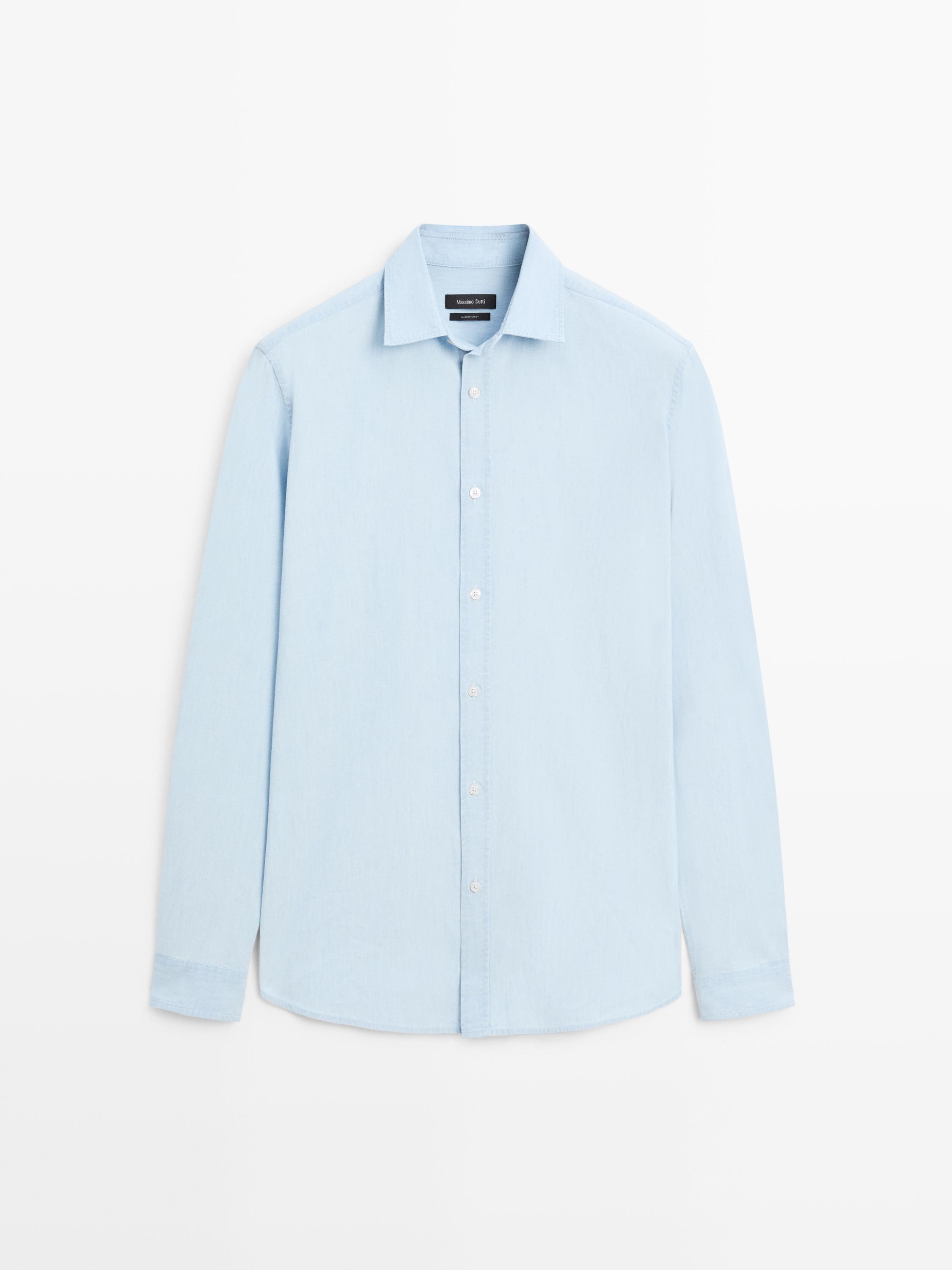 Vista frontal de camisa celeste de manga larga con botonadura central y cuello clásico.