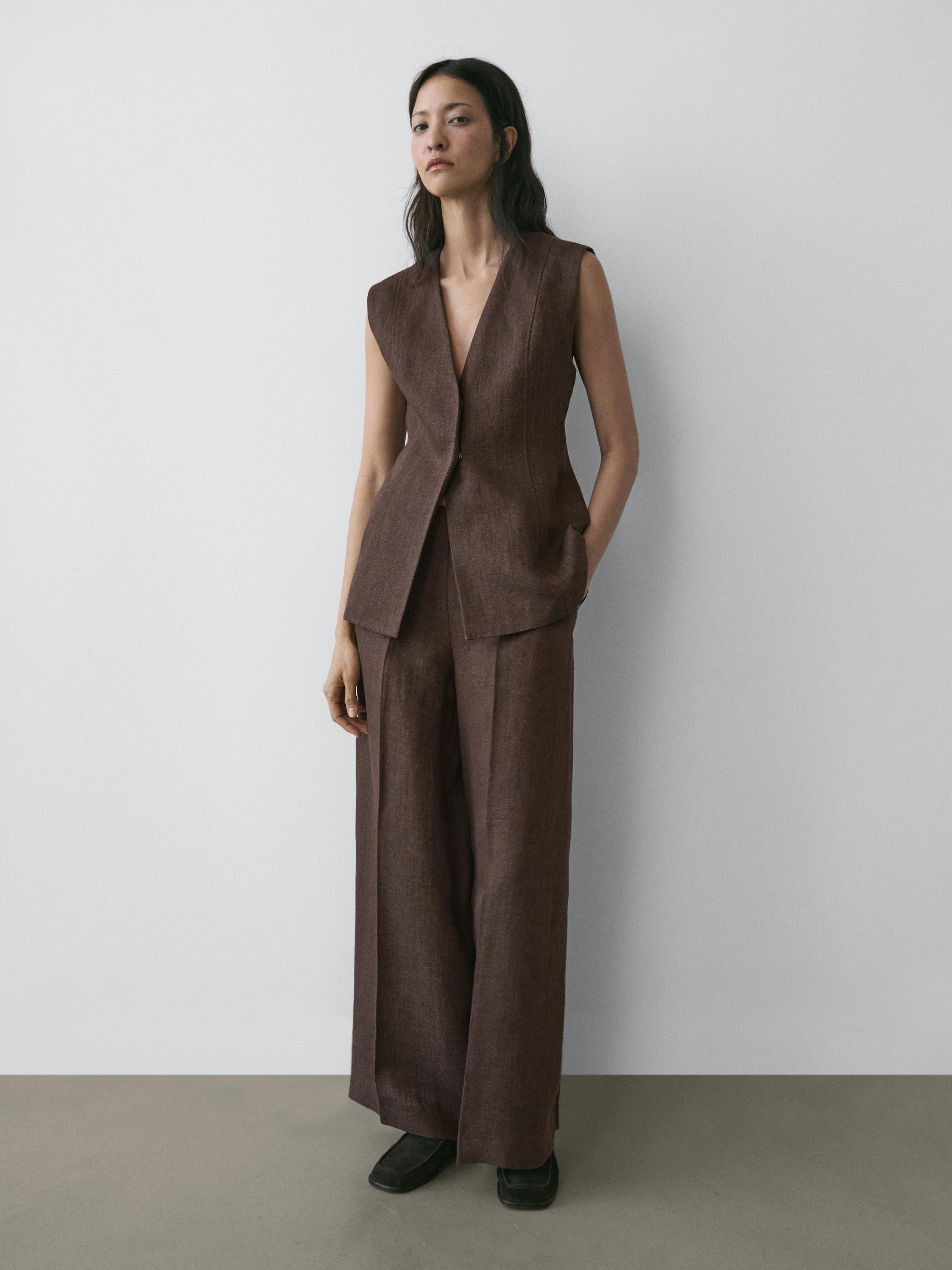 Brown sleeveless vest set with side pockets and wide-leg brown pants.
