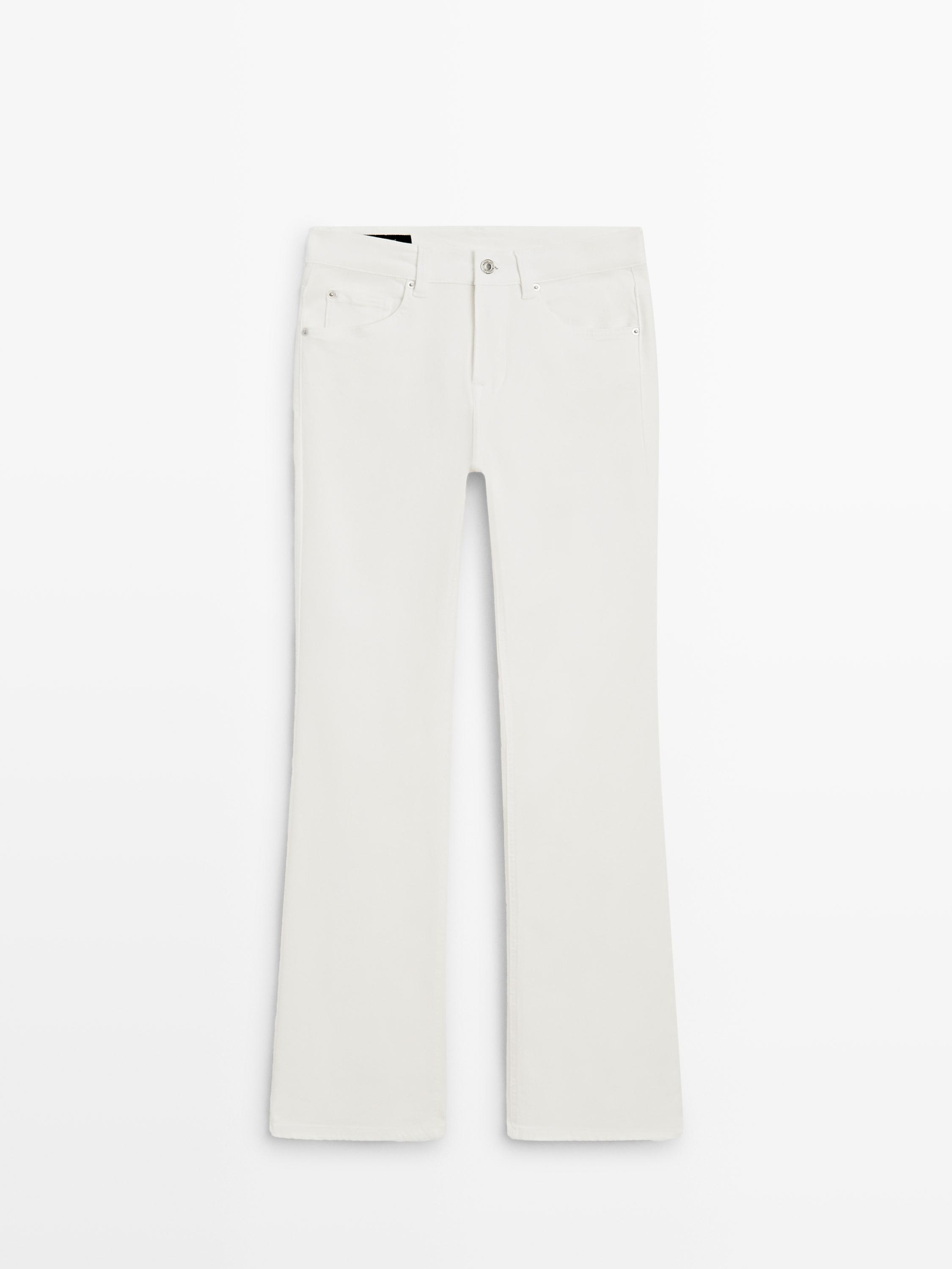 Front view of distressed white jeans, skinny flare cut, with front and back pockets.