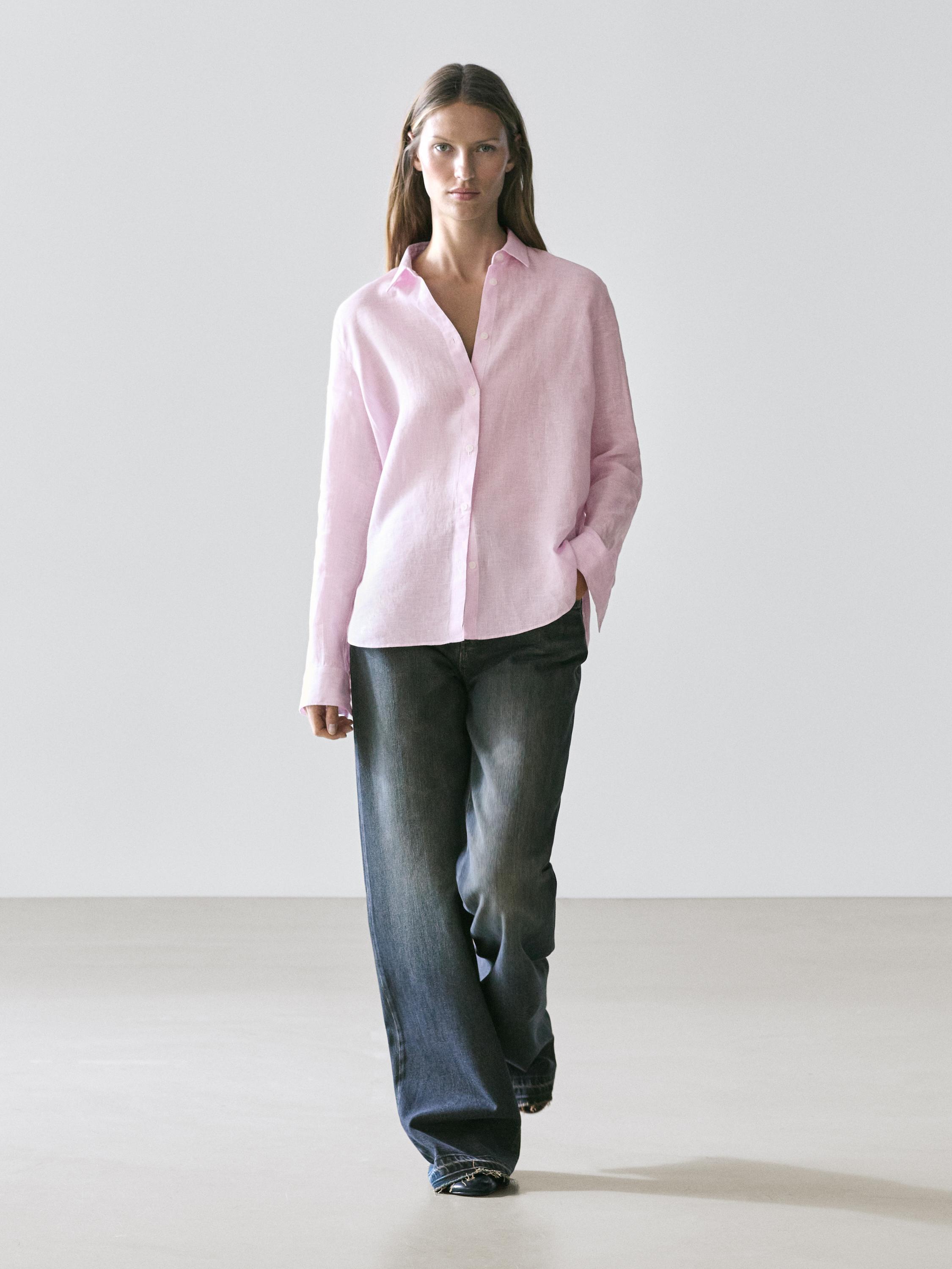 Комплект из струящейся розовой рубашки с боковыми карманами и широких джинсов.