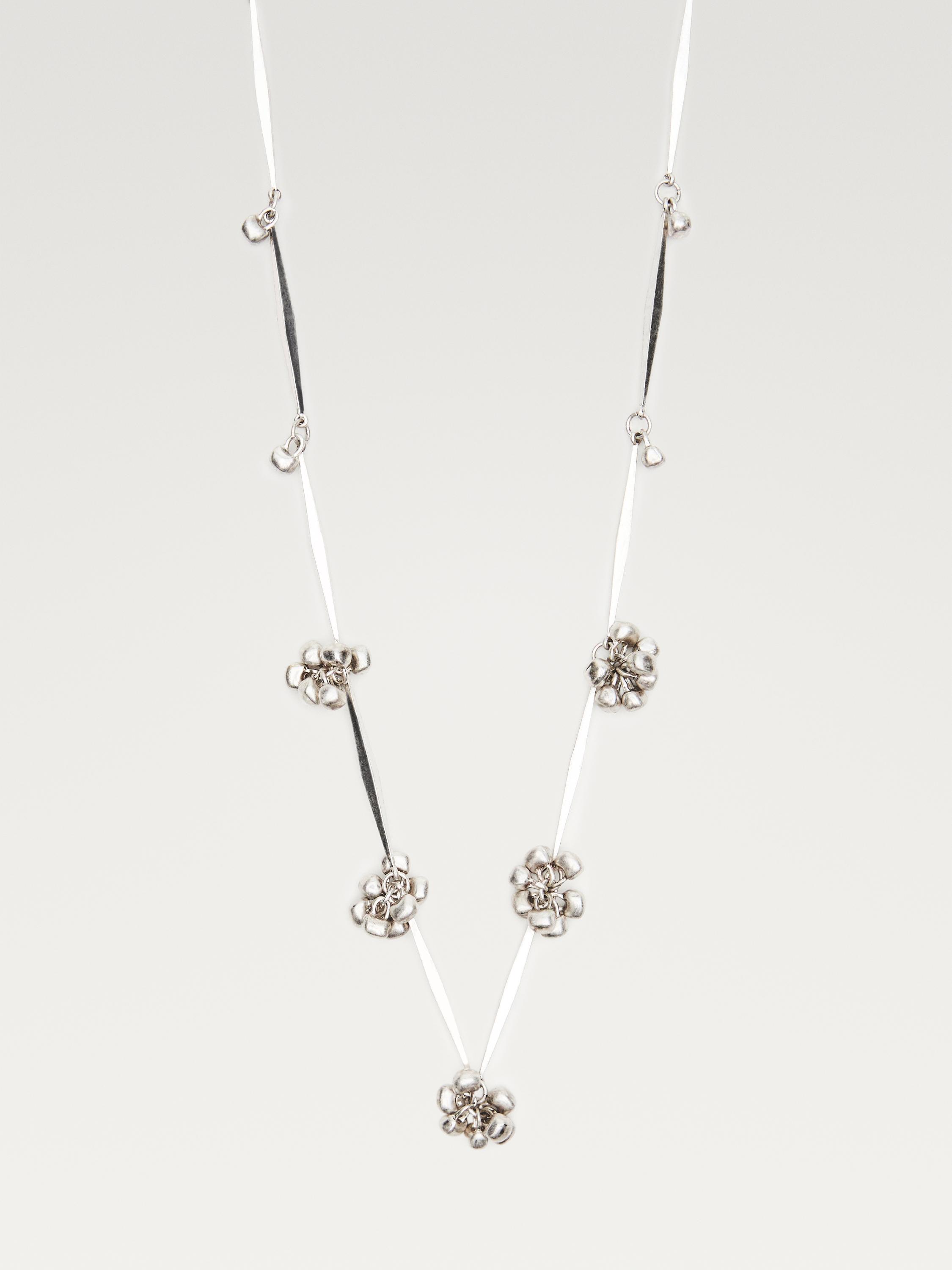 Collar de cadena metálica en plata con detalles de flores en relieve y secciones de cinta negra y blanca.