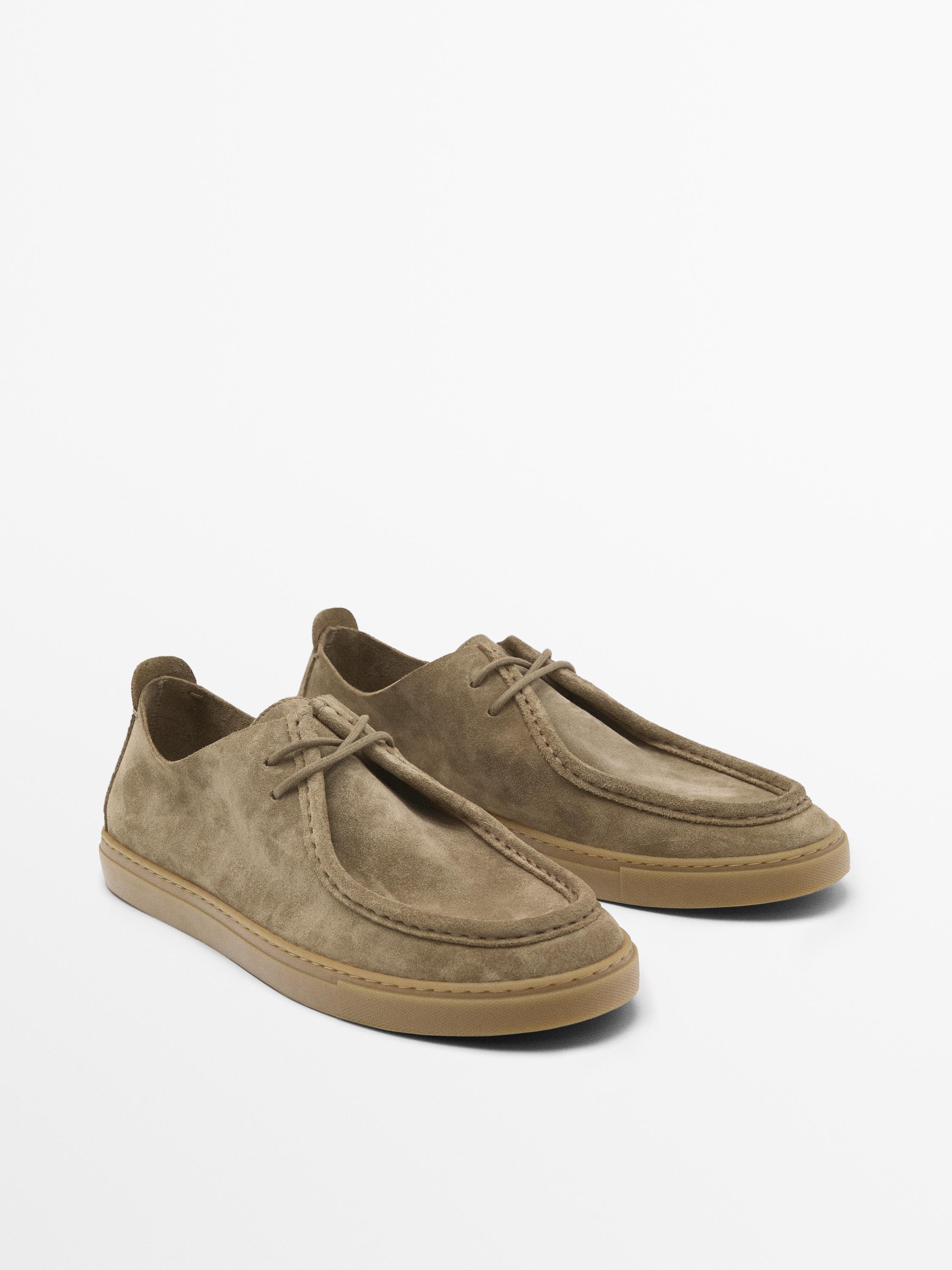 Vue latérale de chaussures beige à lacets avec semelle en caoutchouc.