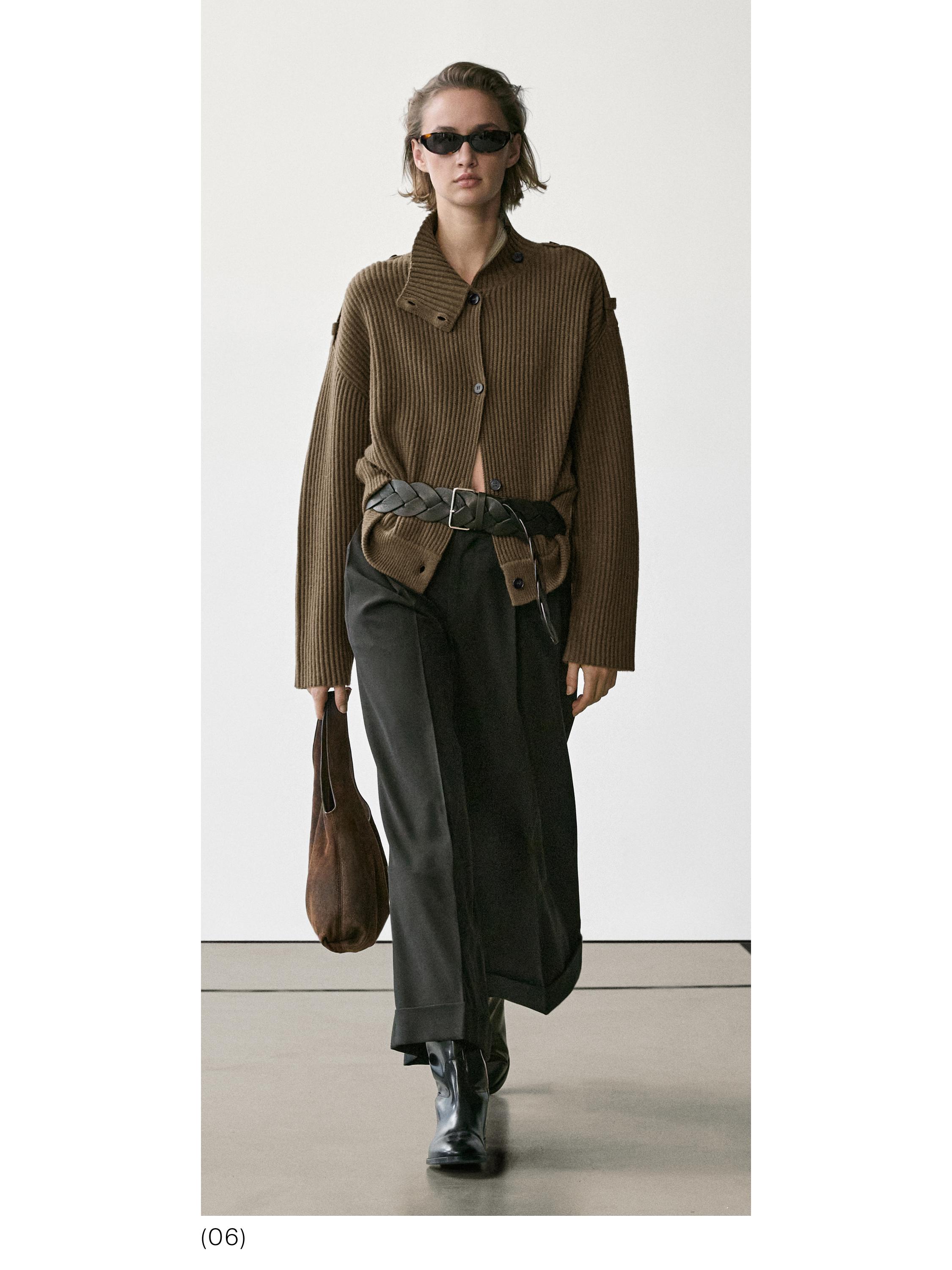 Conjunto de cárdigan marrón de punto con botones, pantalones negros anchos, cinturón trenzado y botas negras.