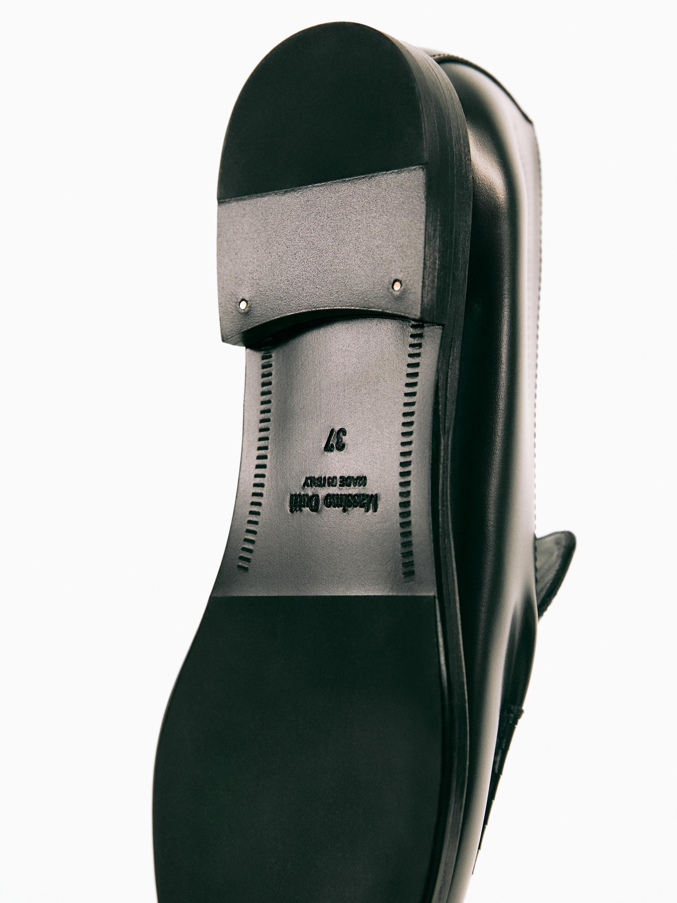 Détail de la semelle de chaussure noire avec le texte "Made in Italy" et le numéro "37".