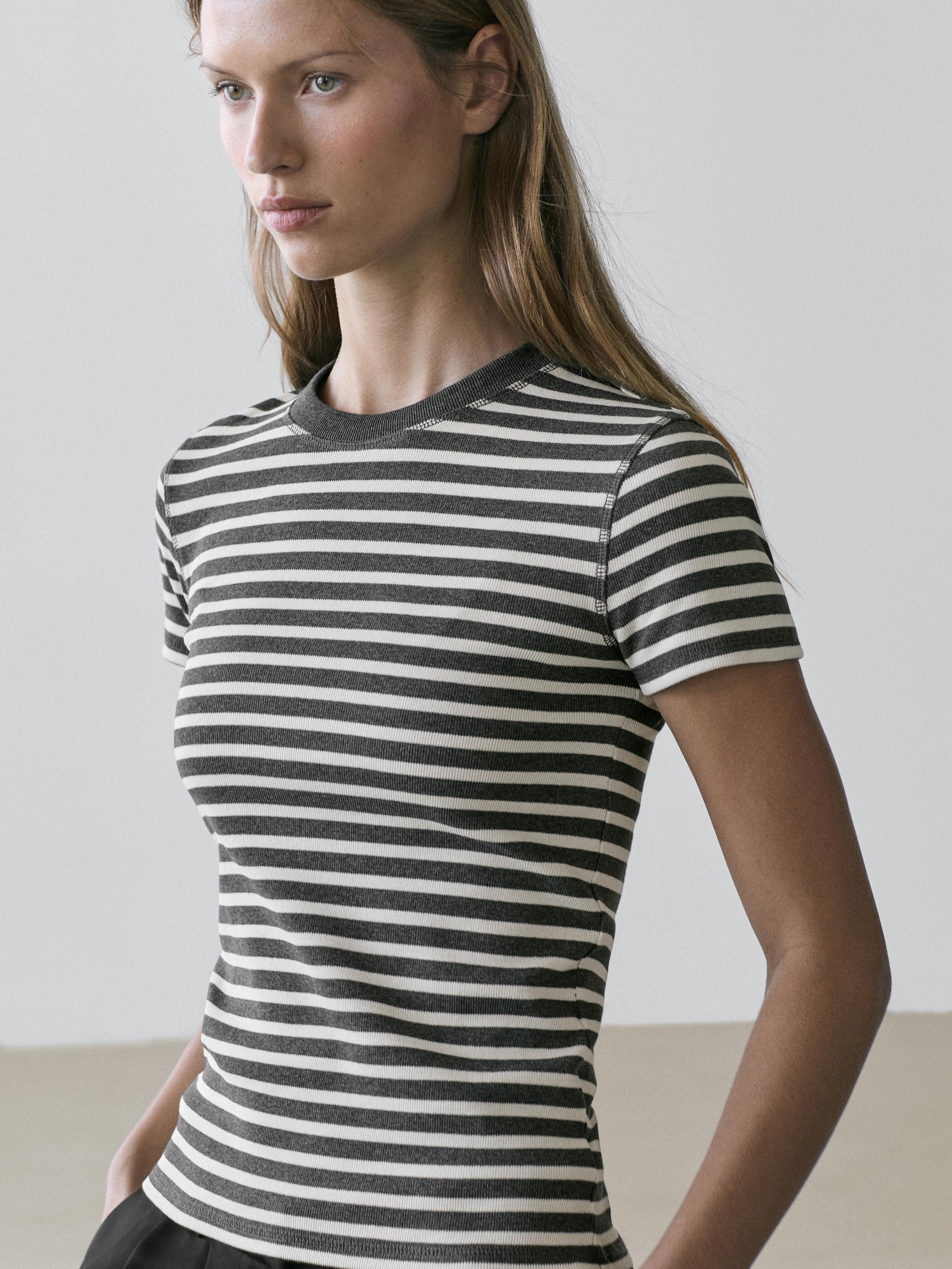 Pilnas pilkų marškinėlių su baltomis juostelėmis, trumpomis rankovėmis ir apvalia apykakle kadras.