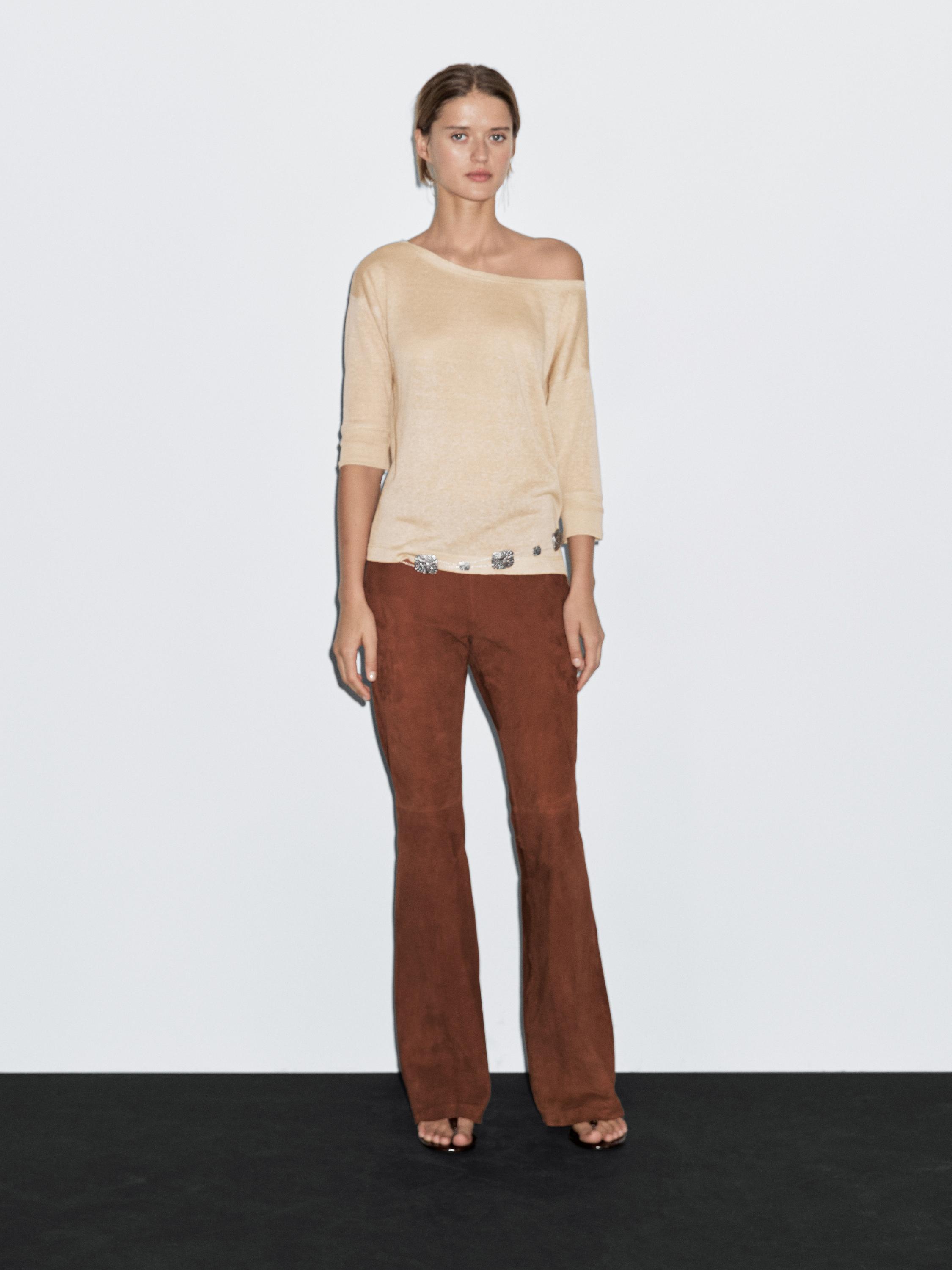 Beige long-sleeved off-the-shoulder top and brown flared pants set.