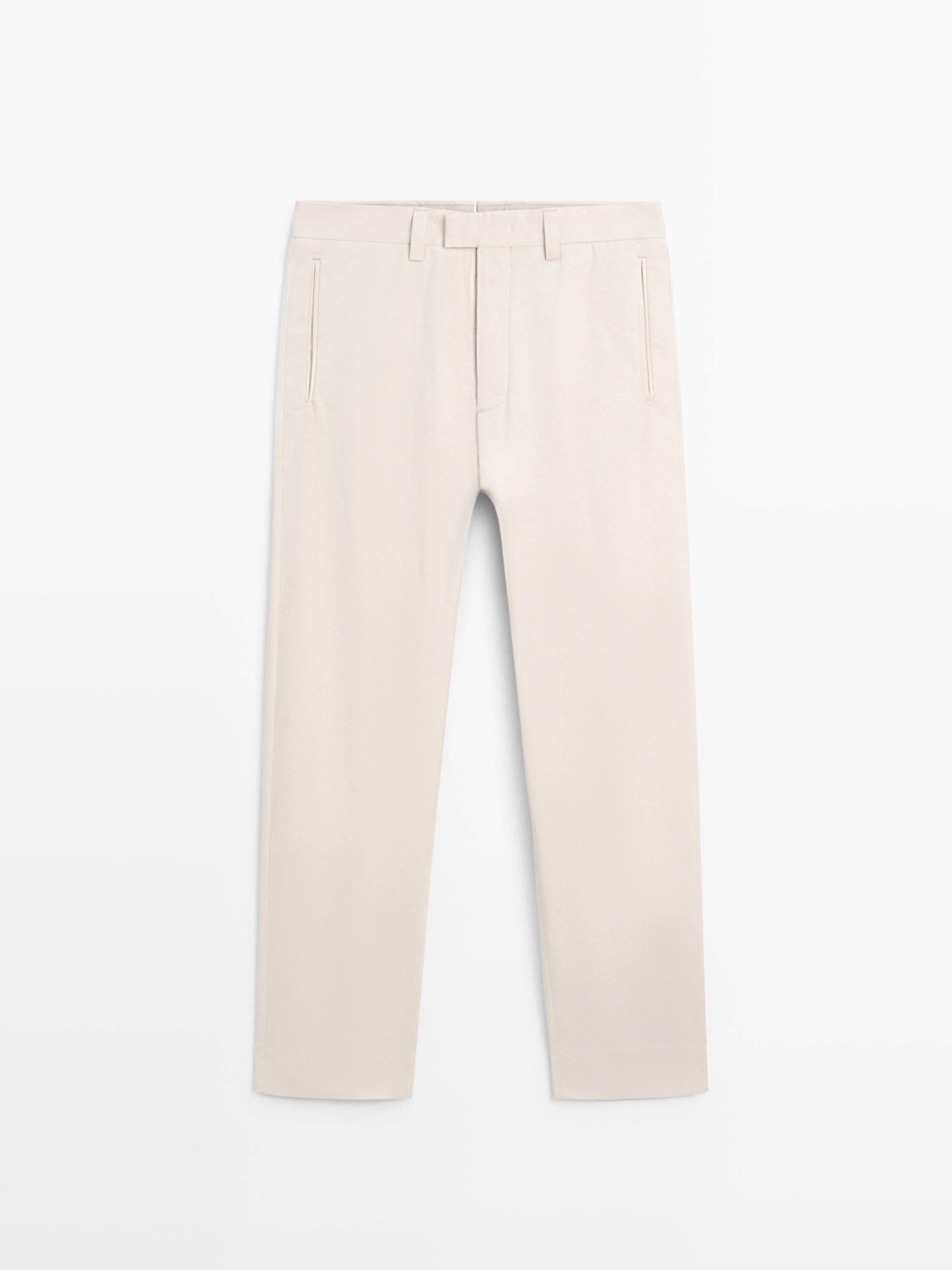 Sprednji pogled na bež slim fit hlače s stranskimi žepi in zankami za pas.