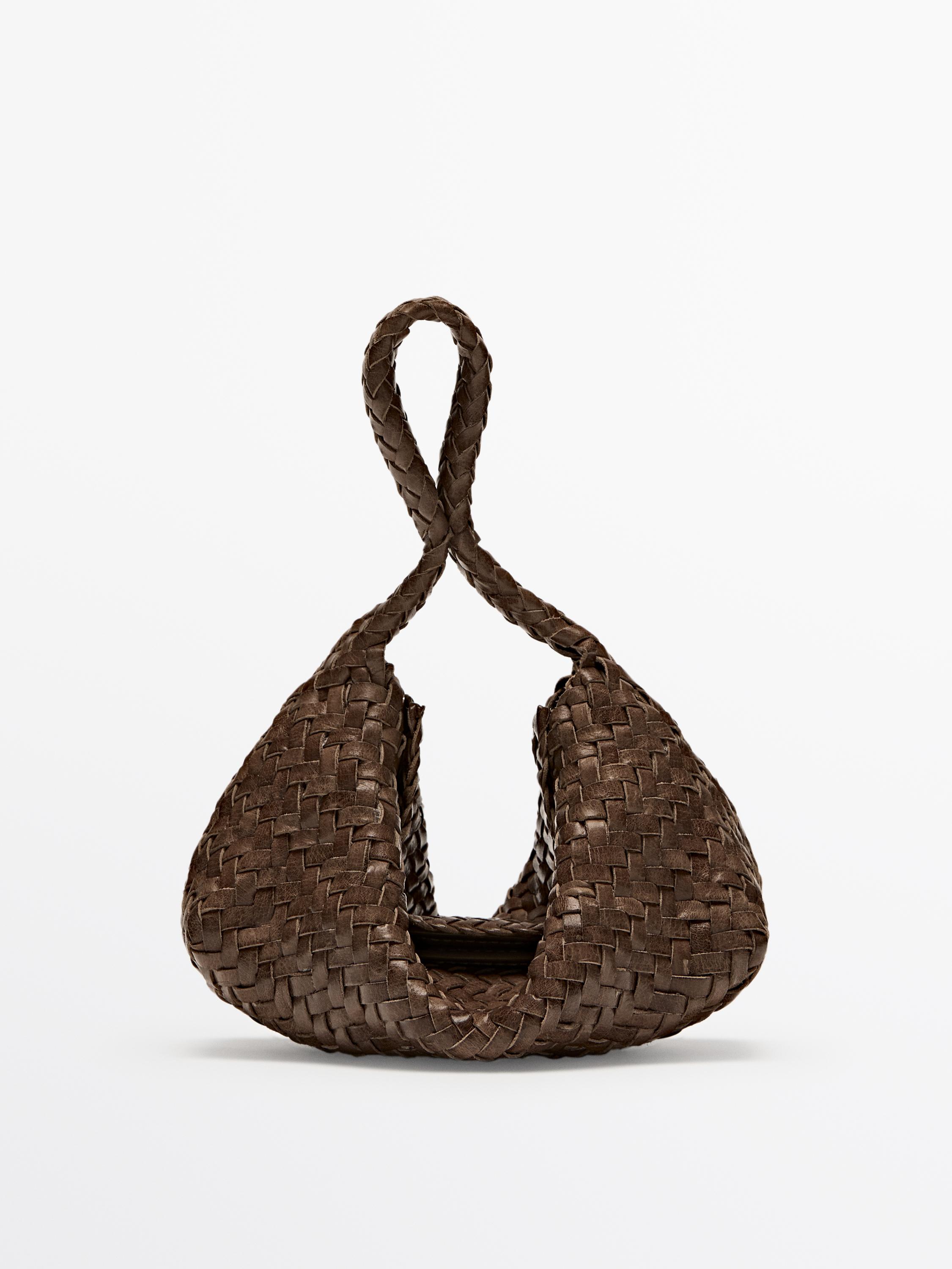 Vista frontal de bolso marrón tejido con asa trenzada.