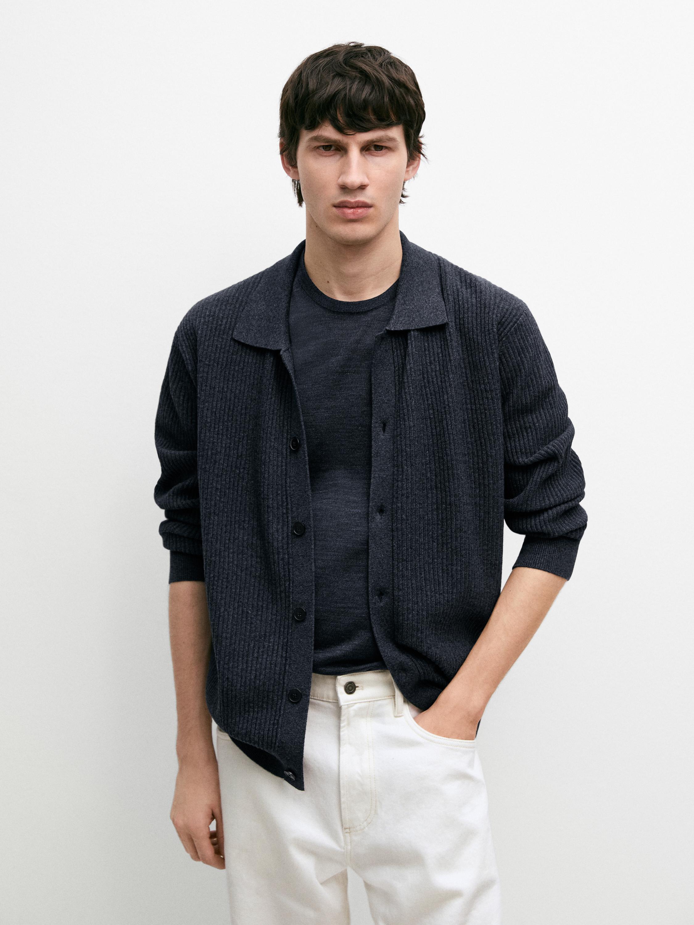 Conjunto de cárdigan indigo de punto canalé con botones y camiseta a juego, pantalones blancos con bolsillos laterales.