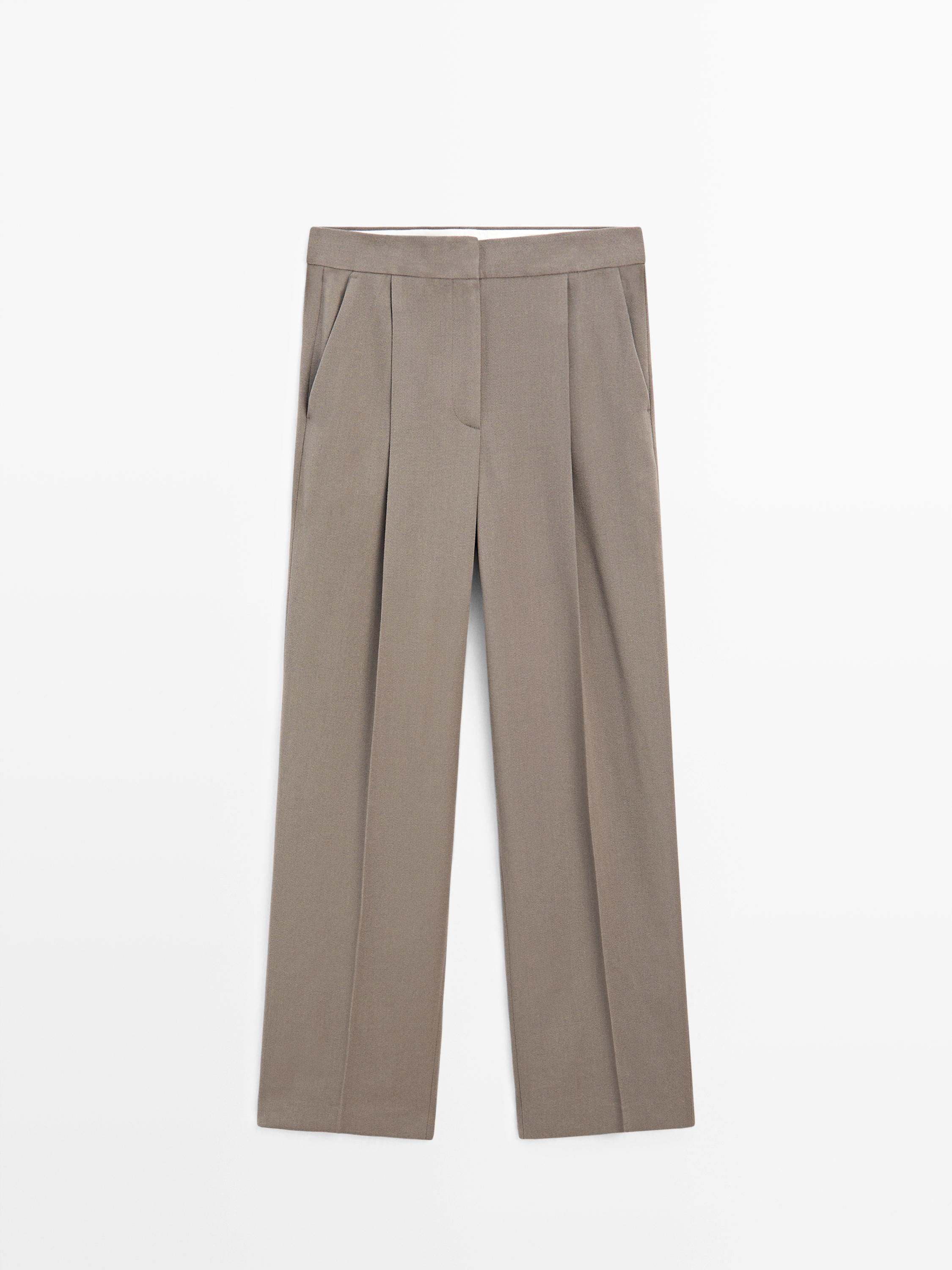 عرض أمامي لبنطال مفصّل باللون الزيتوني مع جيوب جانبية وطيات أمامية.