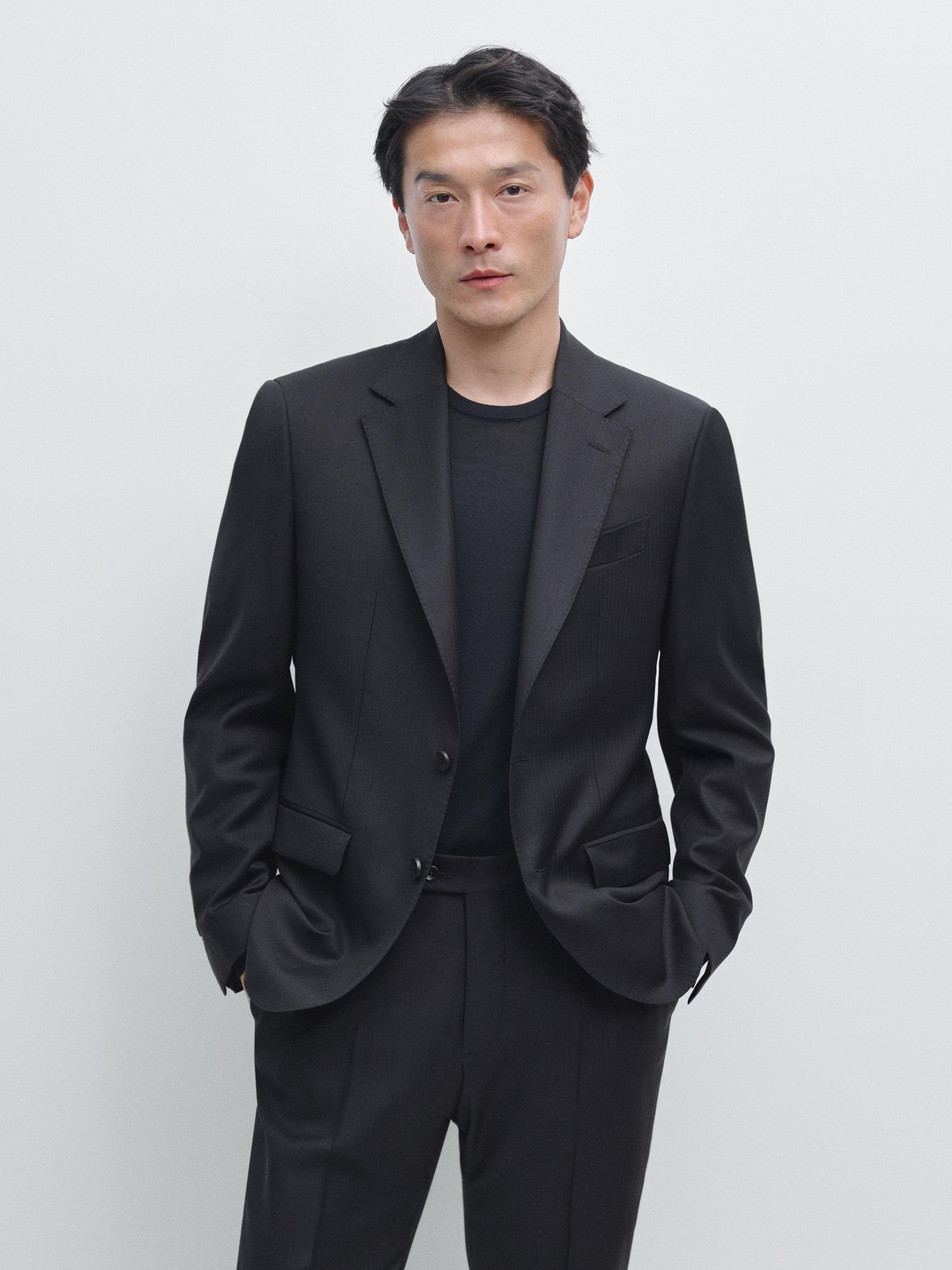 Conjunt d'americana blau marí amb solapes clàssiques i butxaques amb solapa, combinat amb pantalons a joc.