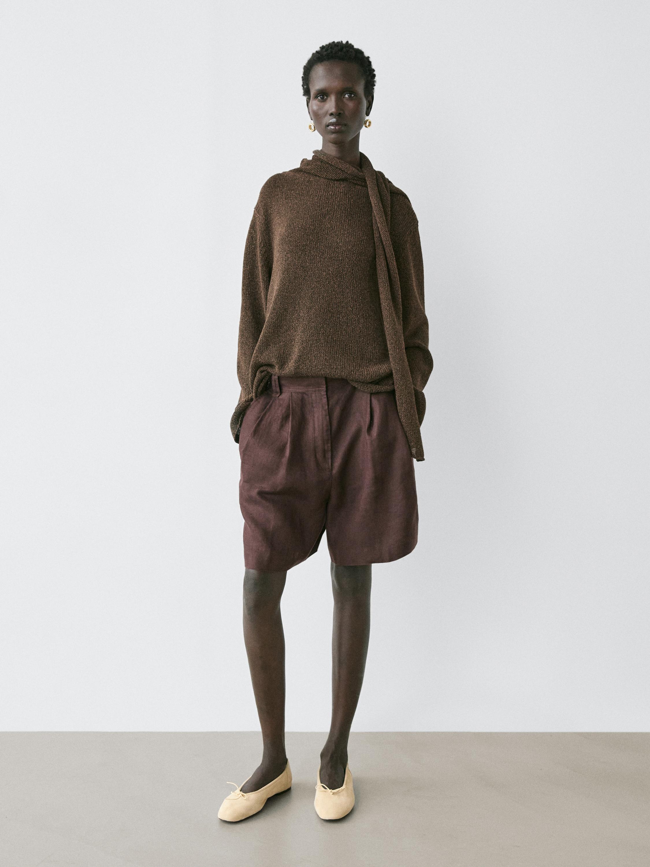 Brown sweater set with a scarf and dark brown shorts, no visible pockets, beige shoes.