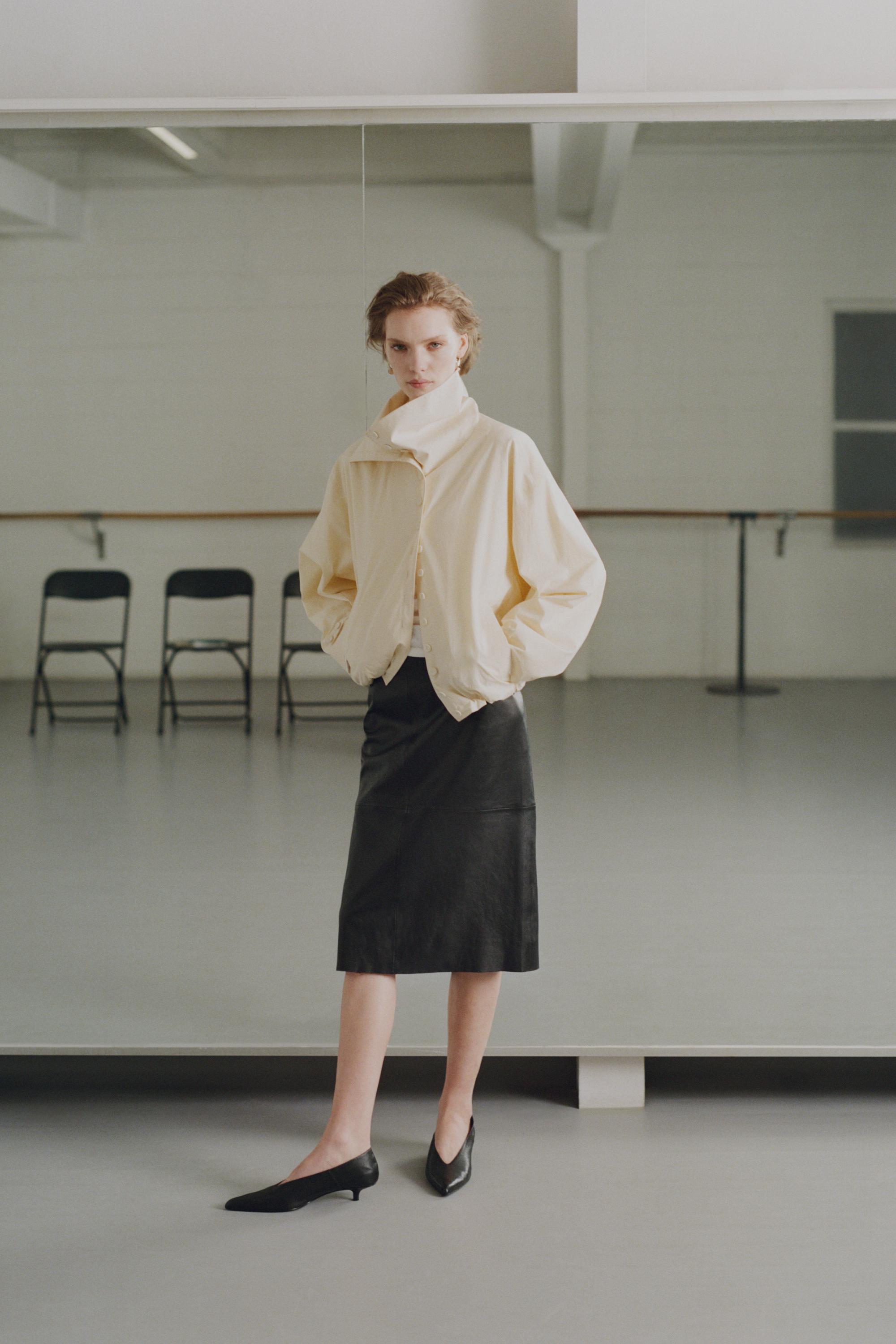 Set aus ecrufarbener Jacke mit Knöpfen und geradem schwarzem Midirock.