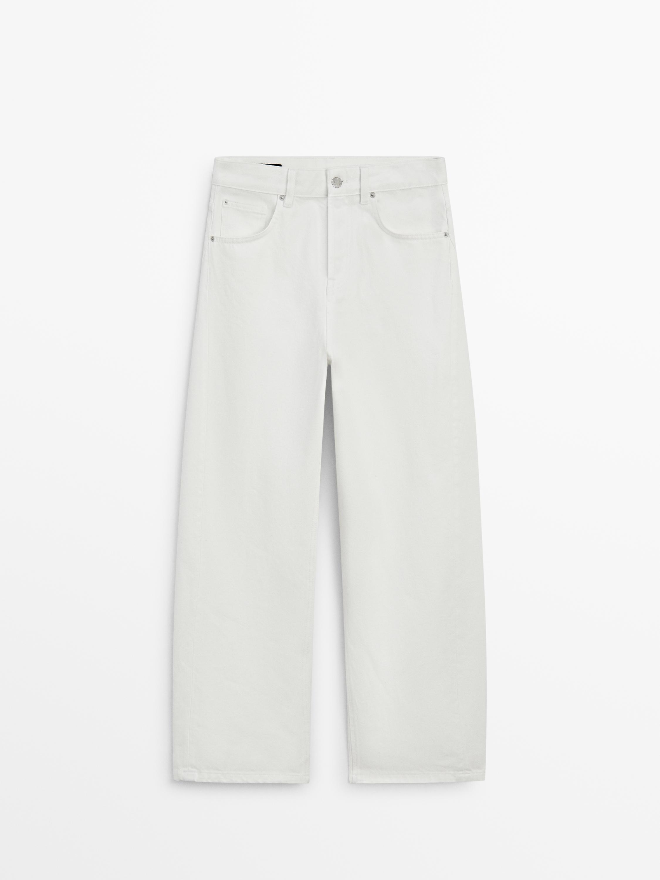 Front view of white straight-cut pants with five pockets and button and zipper closure.