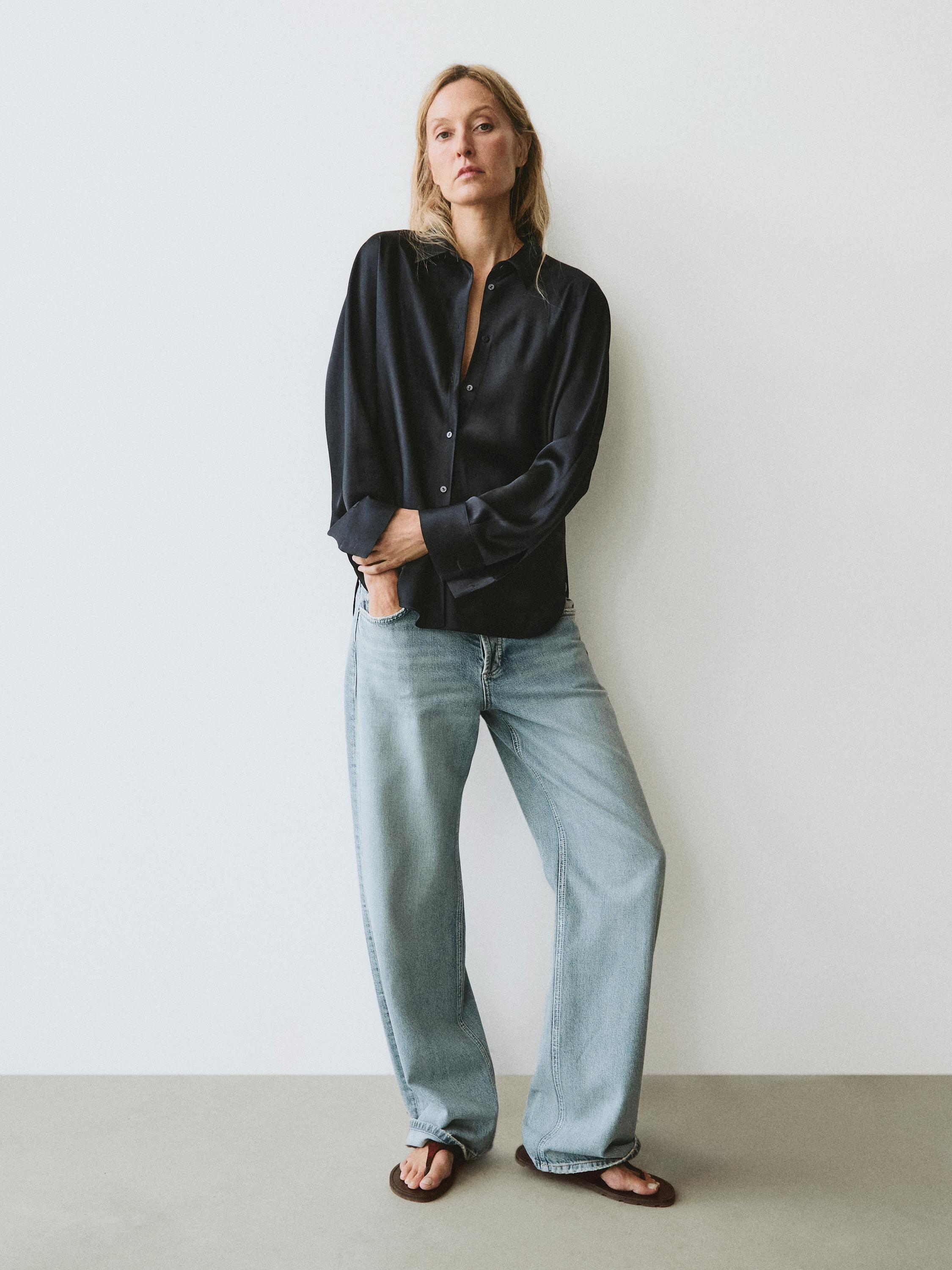 Conxunto de camisa azul escuro satinada con botóns e vaqueiros anchos claros.
