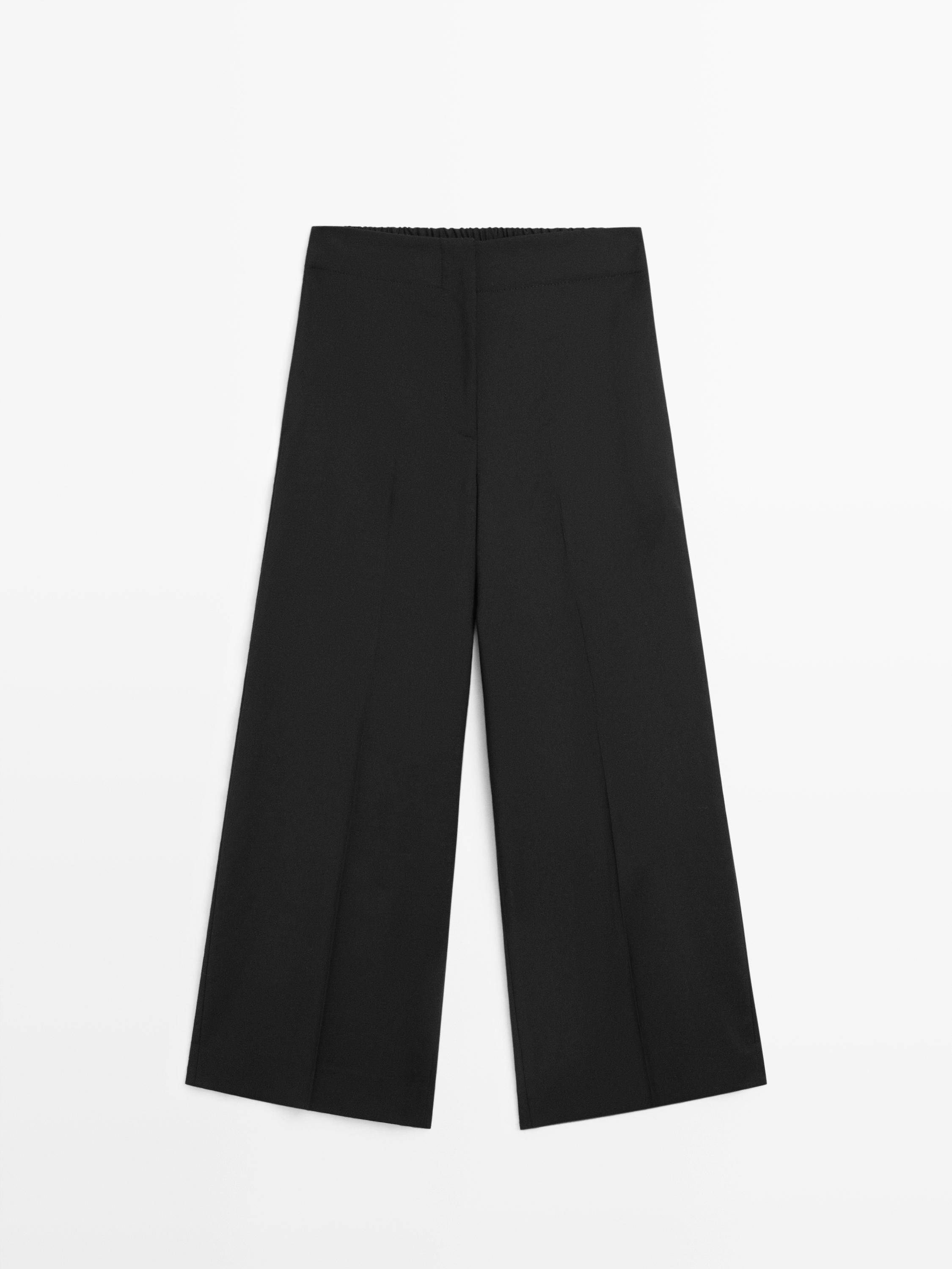 Pamje ballore e pantallonave të zeza të gjera crop me bel elastik dhe prerje të drejtë.