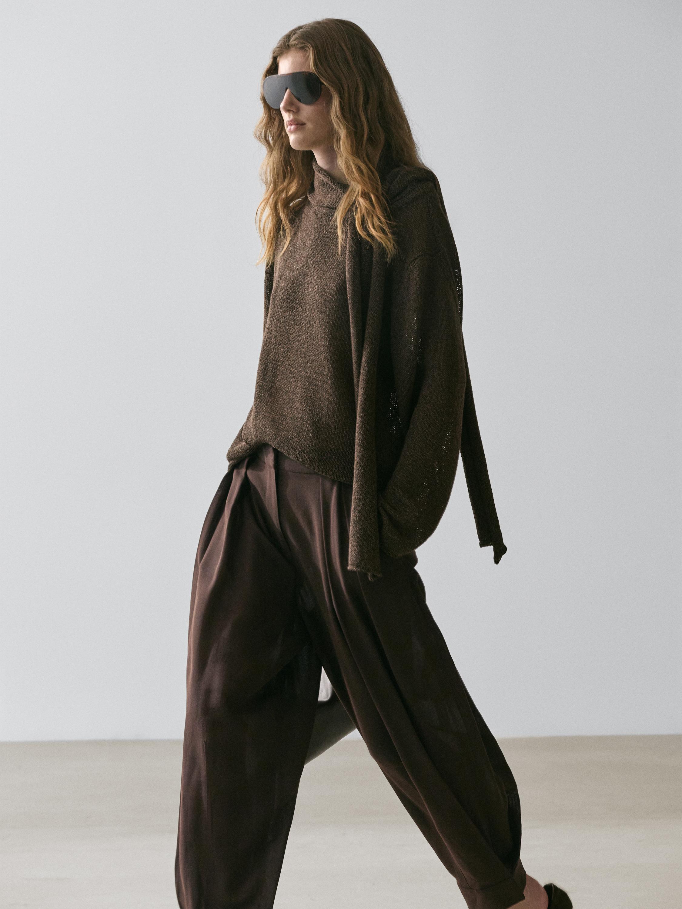 Brown turtleneck sweater and brown pants set with button detail.