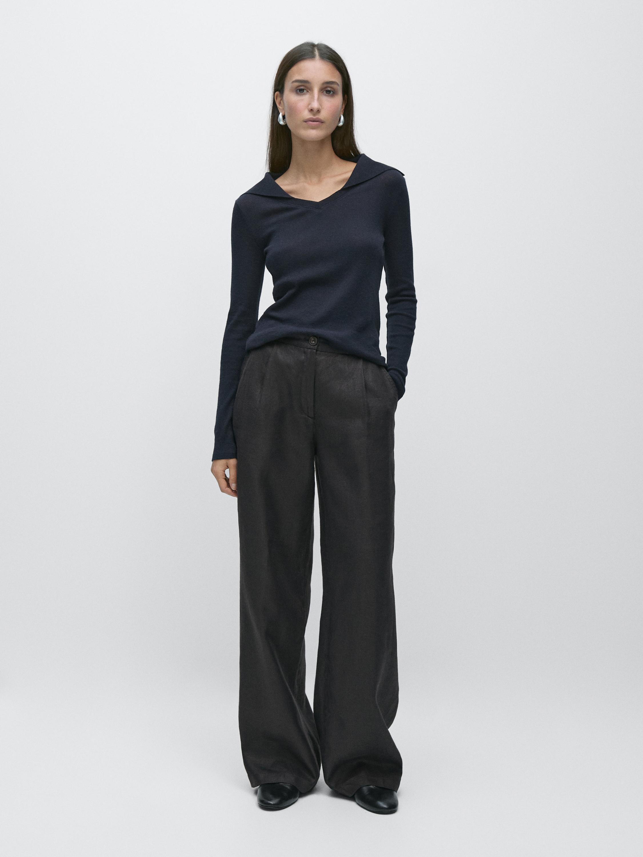 Black wide-leg pants set with elastic waist and long-sleeved black blouse.