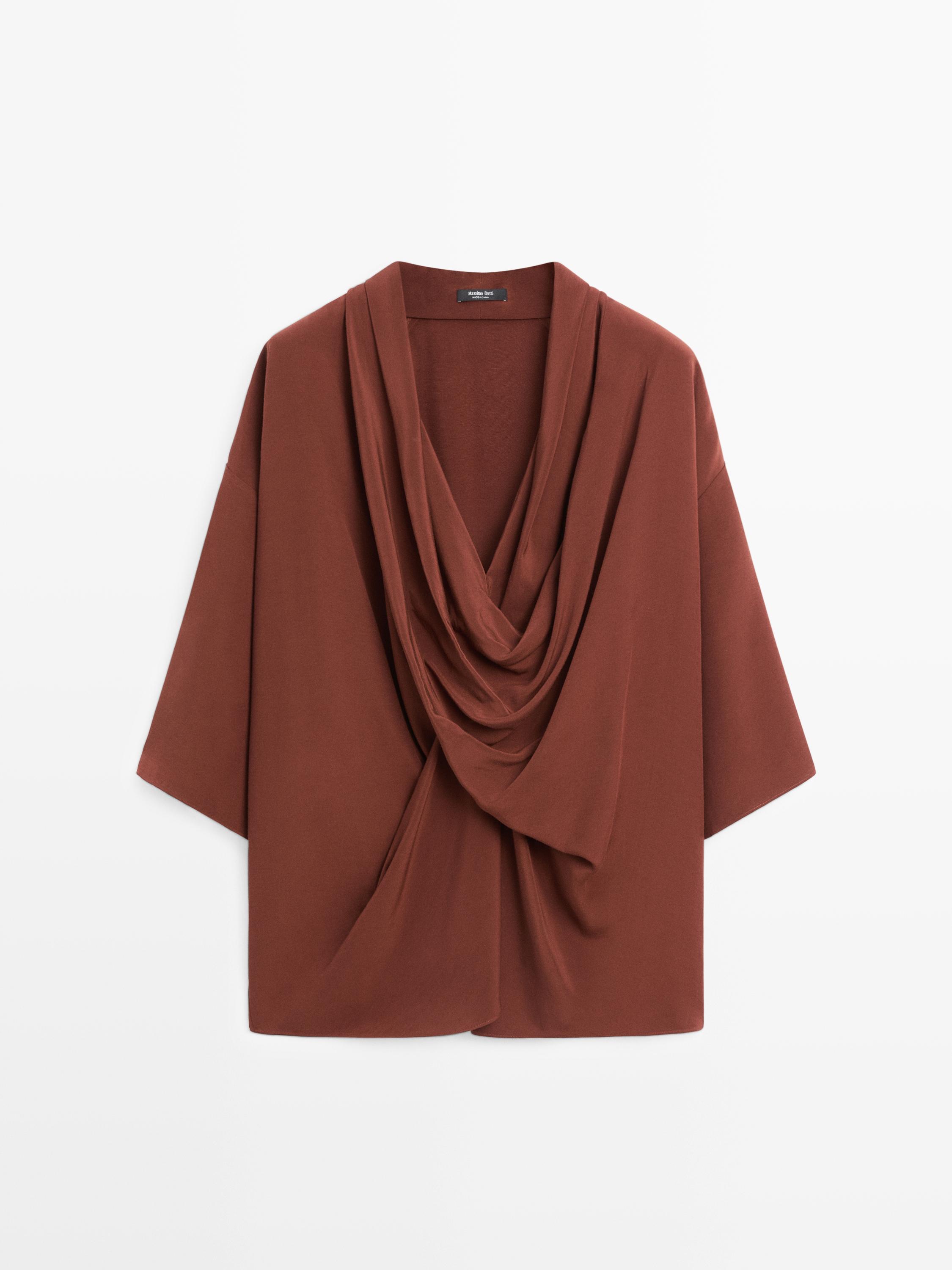 منظر أمامي لقميص برتقالي بياقة مكشكشة وأكمام قصيرة.