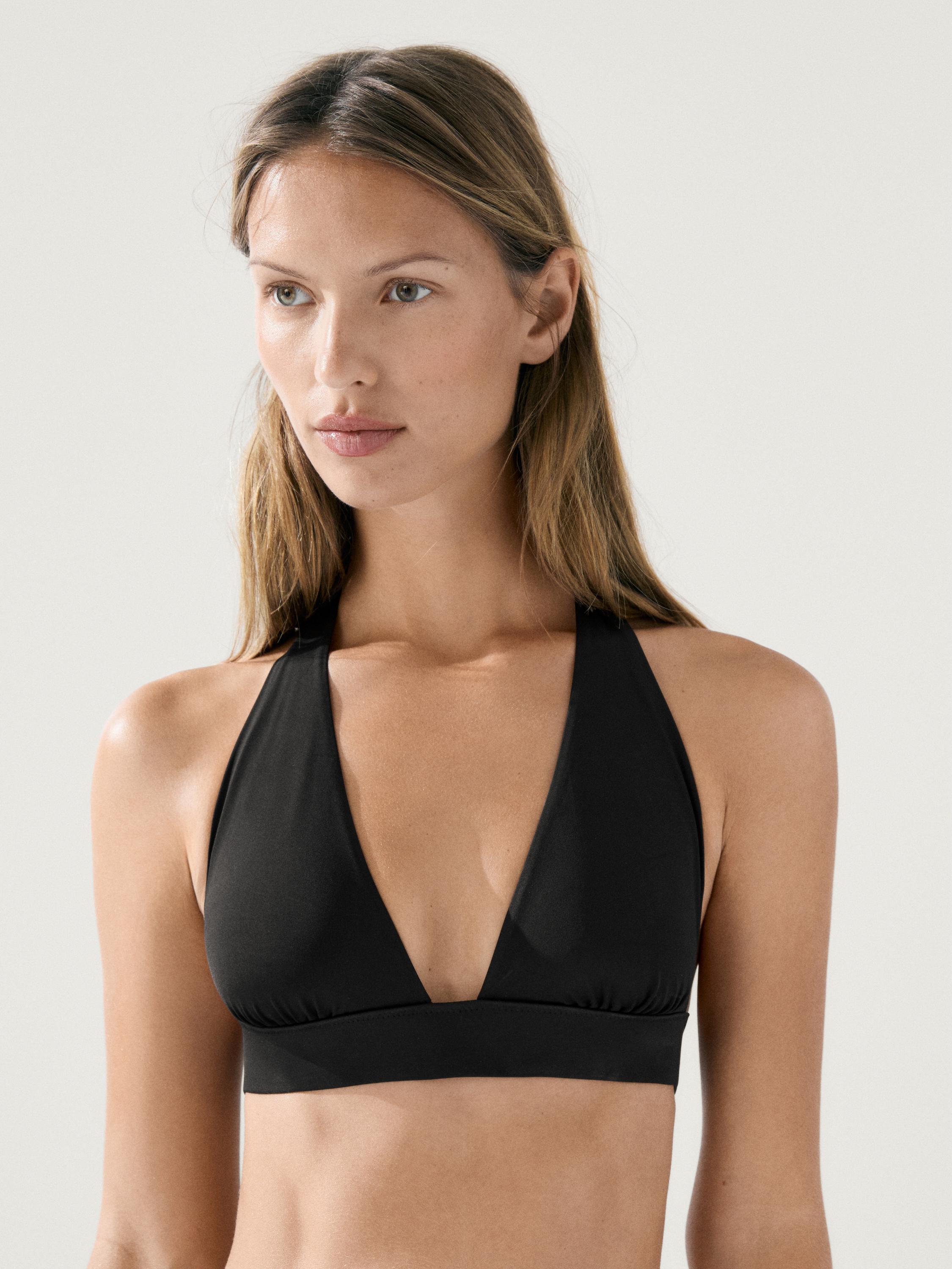 Primer plano de top de bikini negro con escote en V profundo y tirantes anchos.