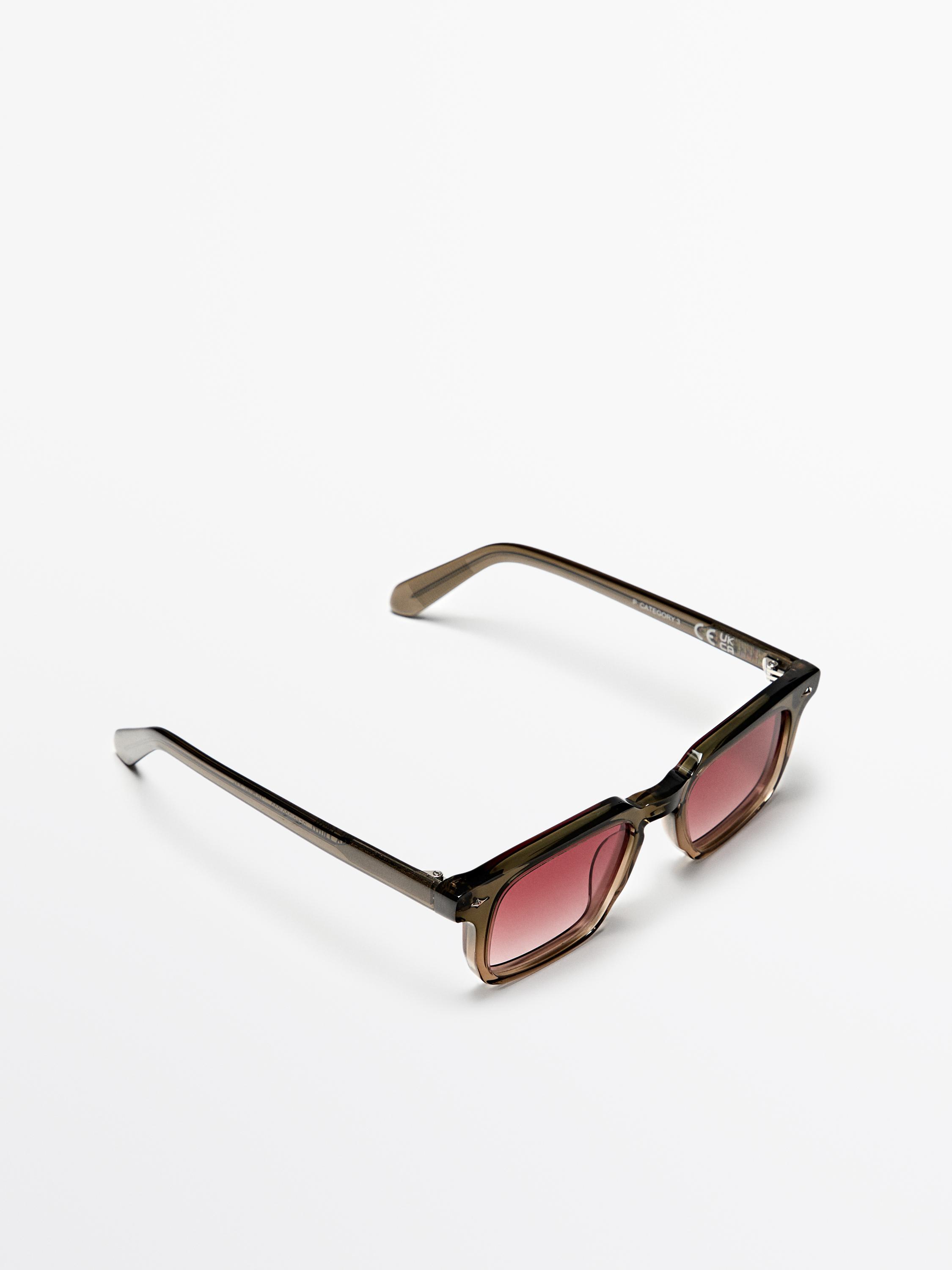 Kare çerçeveli ve pembe renkli camlara sahip vizon rengi güneş gözlüğü.