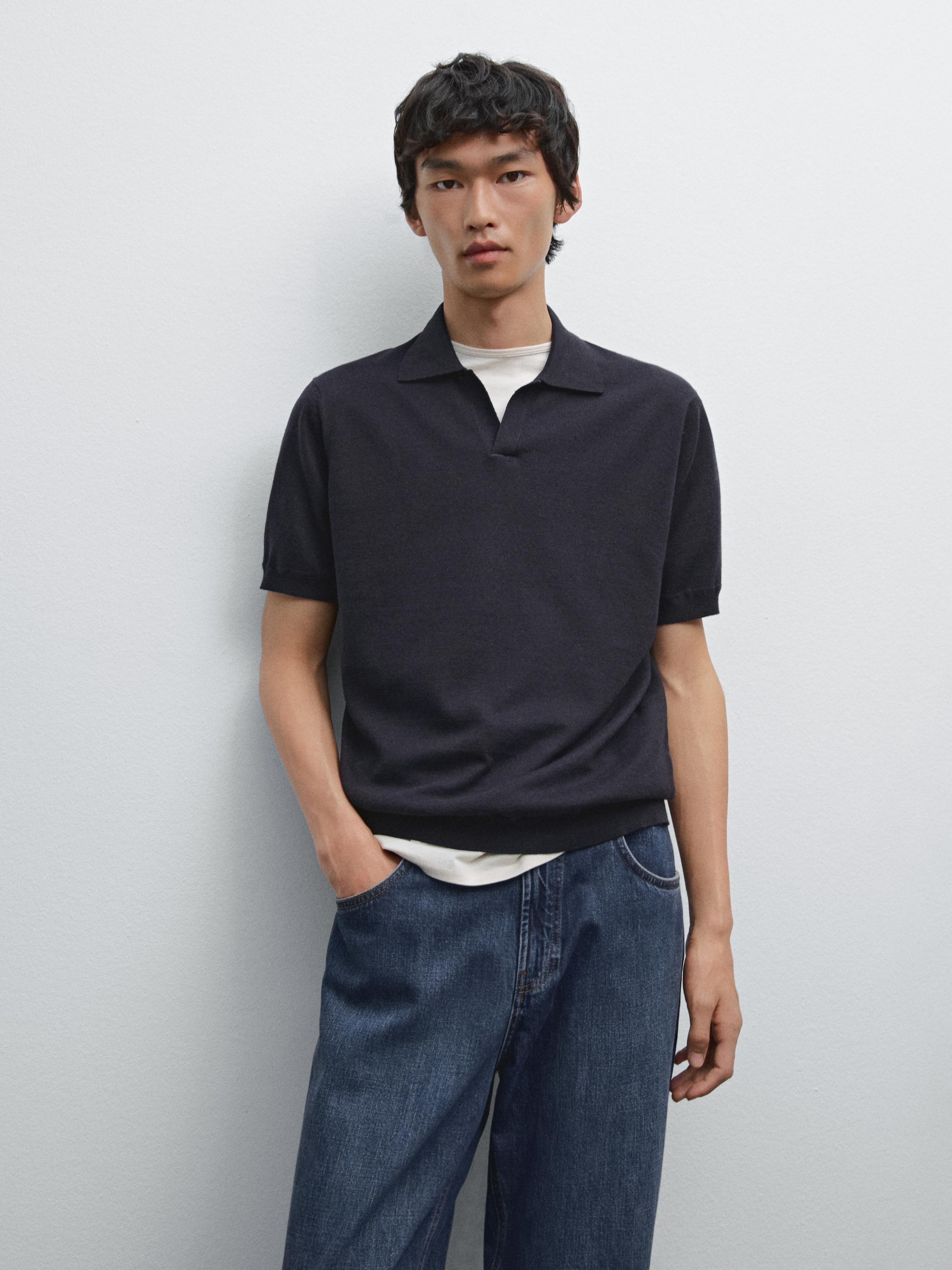 Ensemble polo noir et jeans bleus.