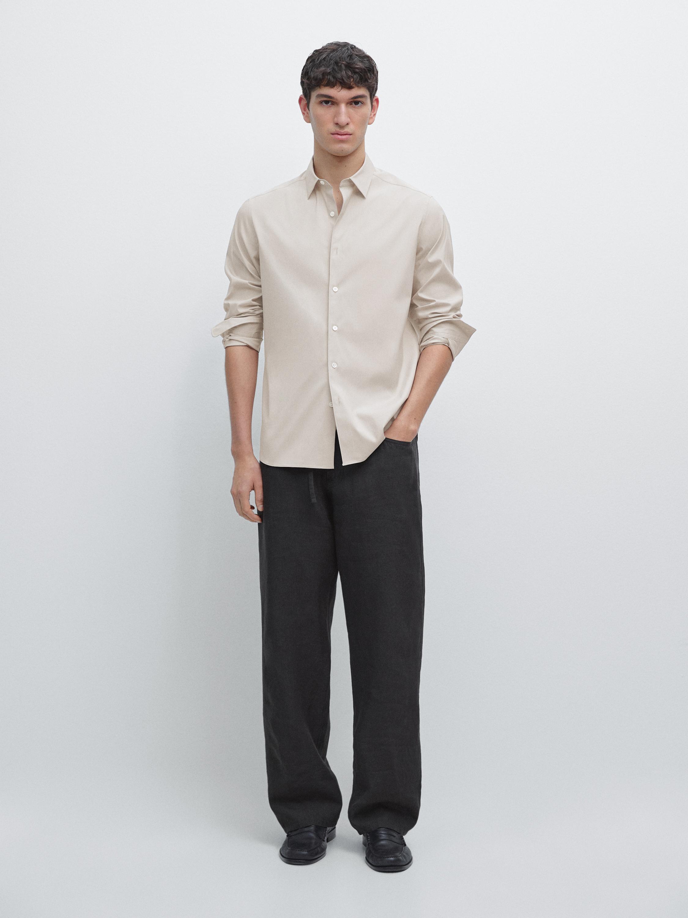 طقم قميص بيج بقصة عادية بأزرار وبنطلون أسود واسع.