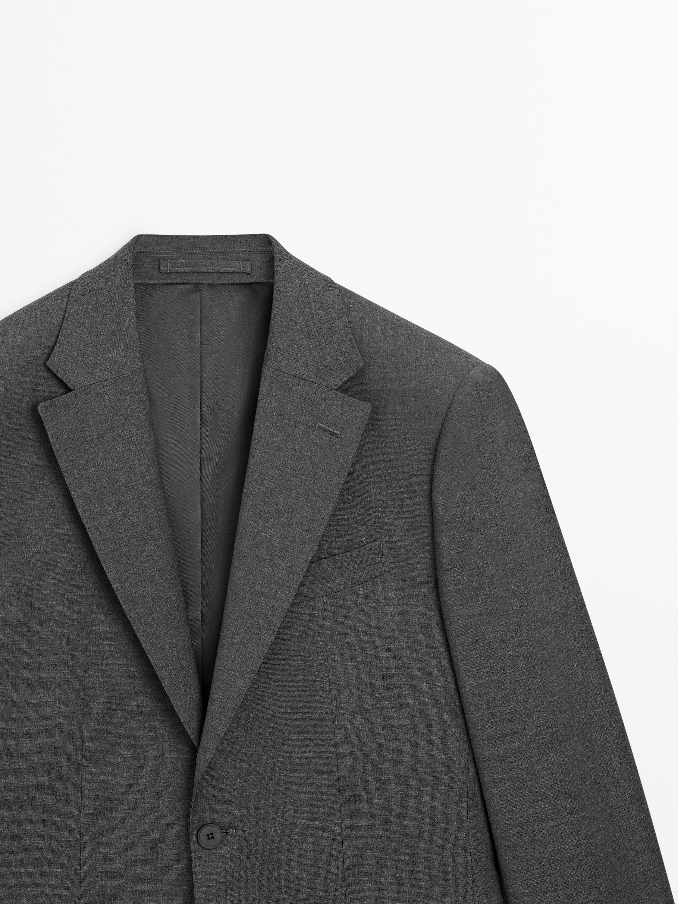 Medium shot of a gray blazer with a notched lapel, left chest pocket, and visible one-button closure.