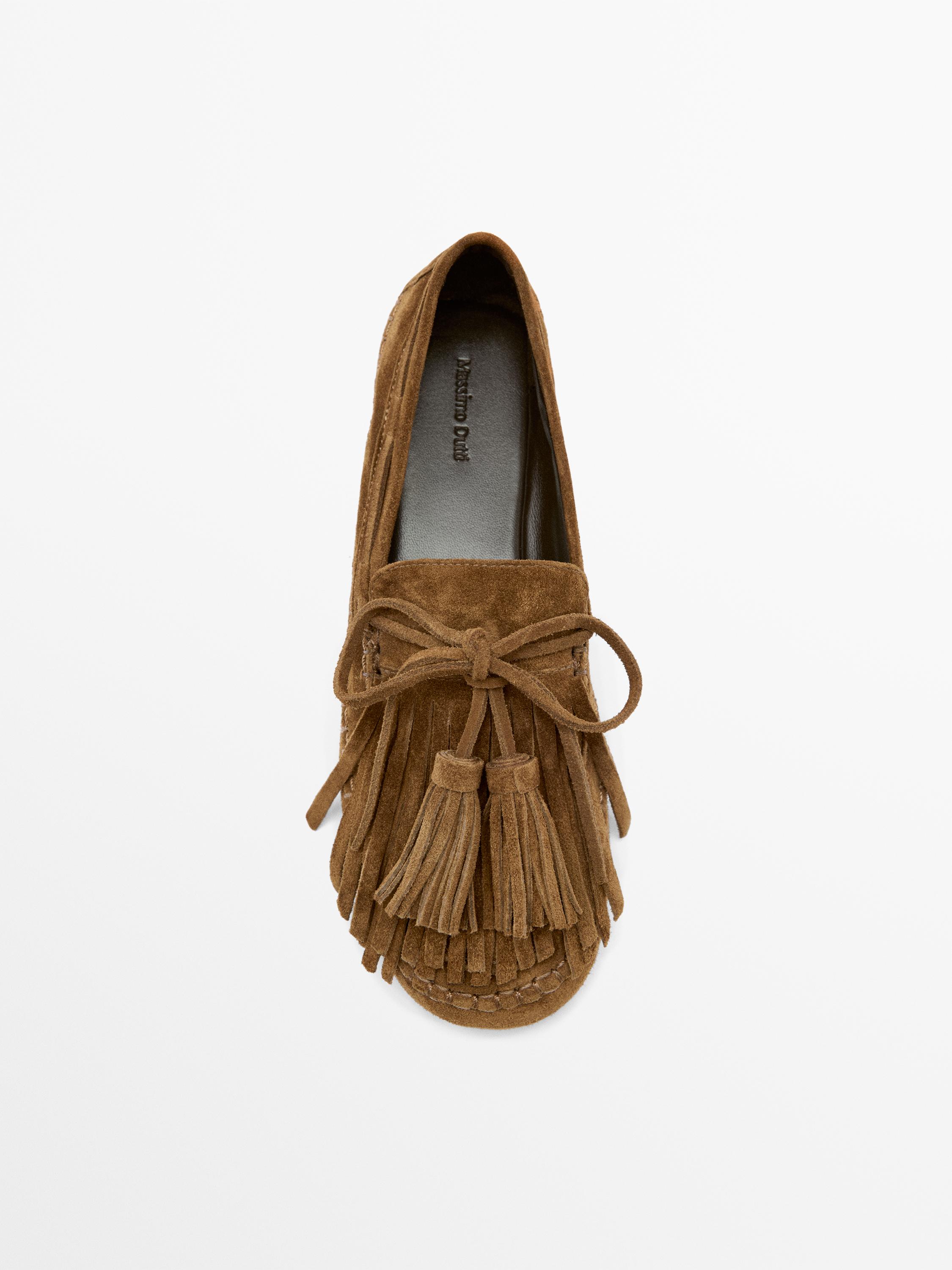 Top view of a leather-colored loafer with fringes and tassels on the front. Visible text: "Massimo Dutti".