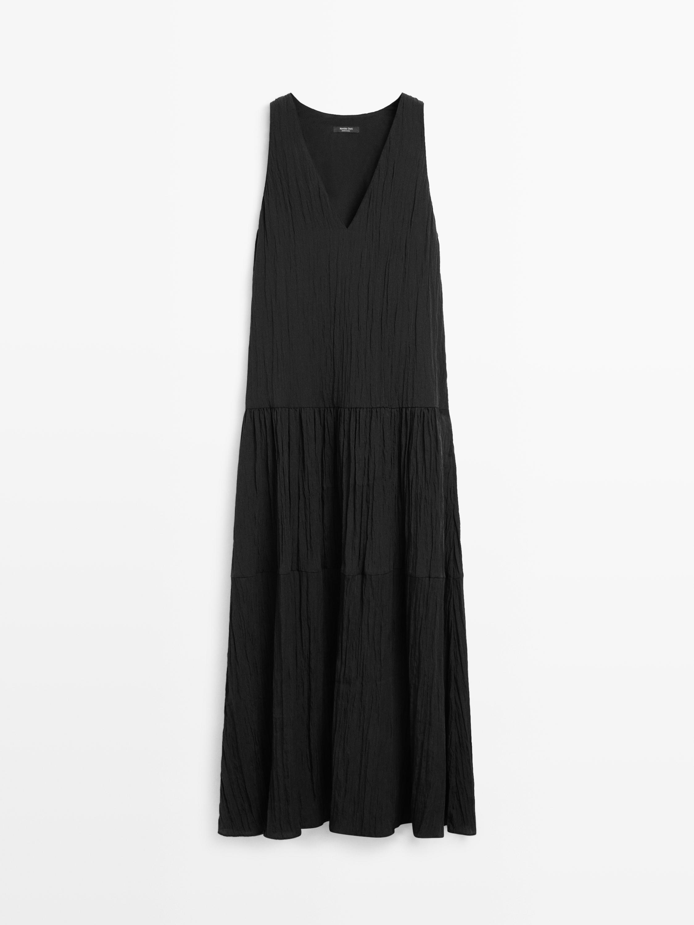 Vista frontal de vestido midi preto fluido plissado com decote em V e sem mangas.