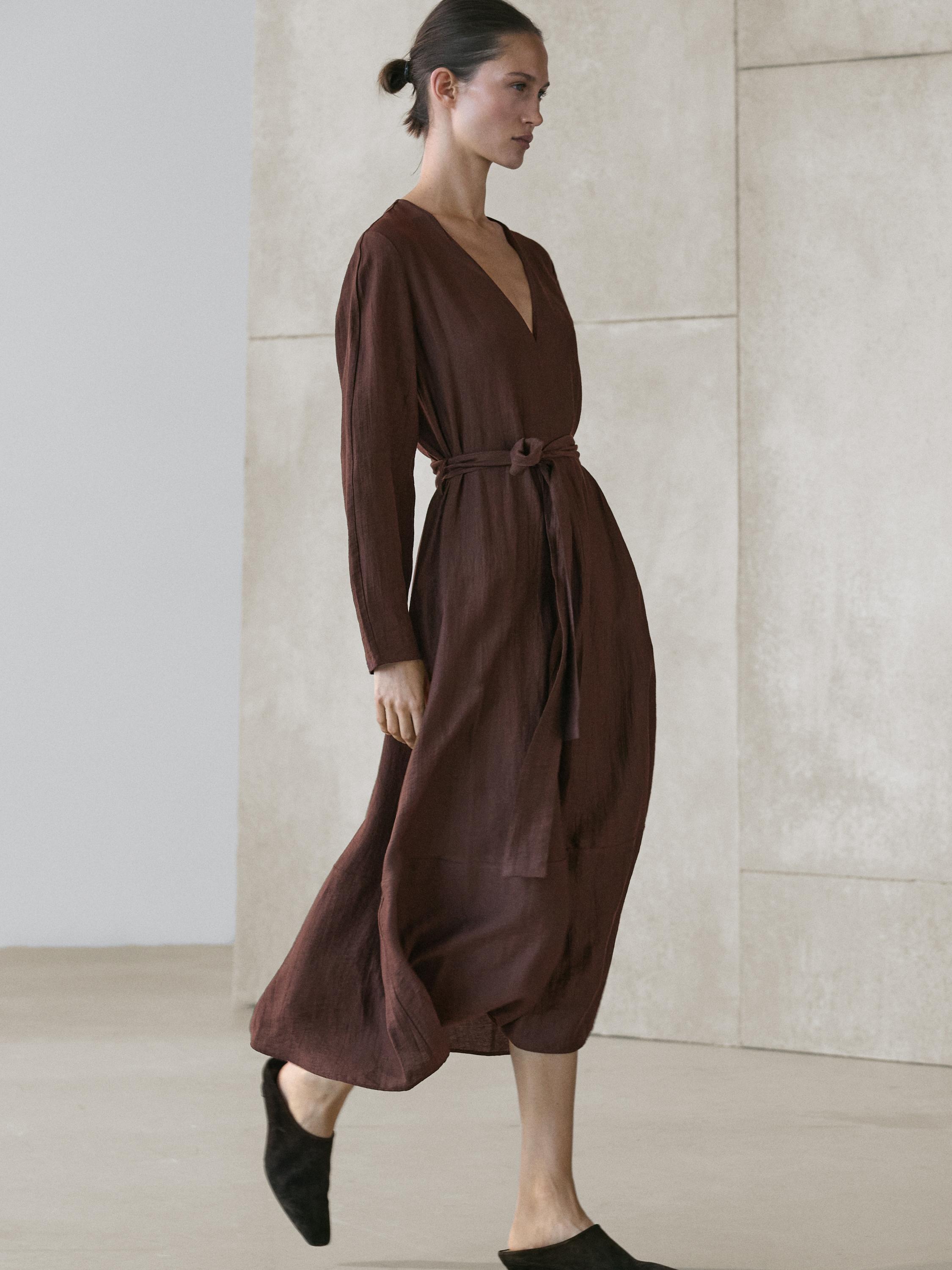 Ensemble robe midi fluide marron avec ceinture et décolleté en V, manches longues.