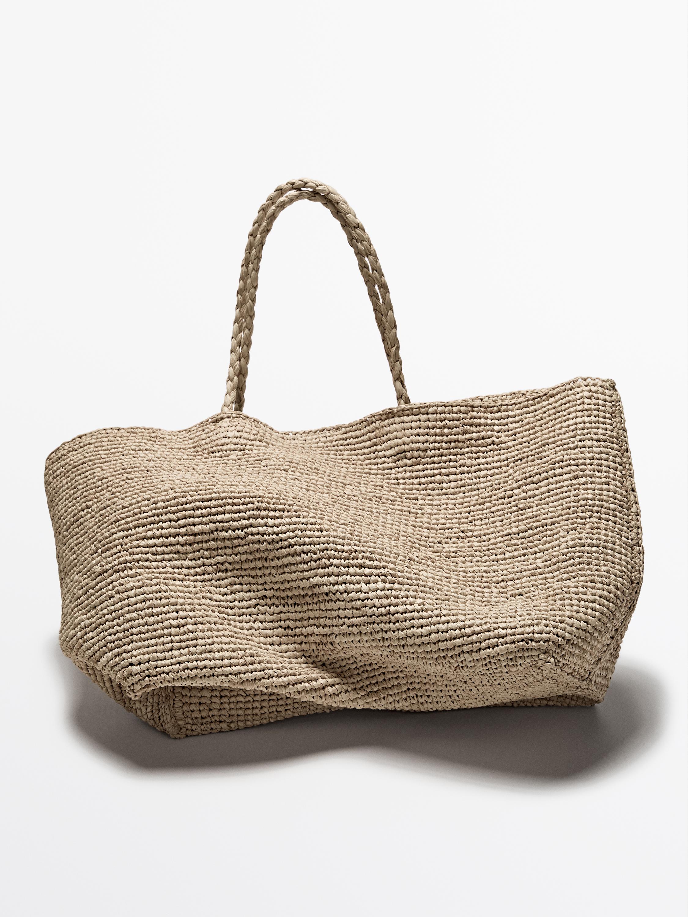 Front view of beige woven bag with braided handles.