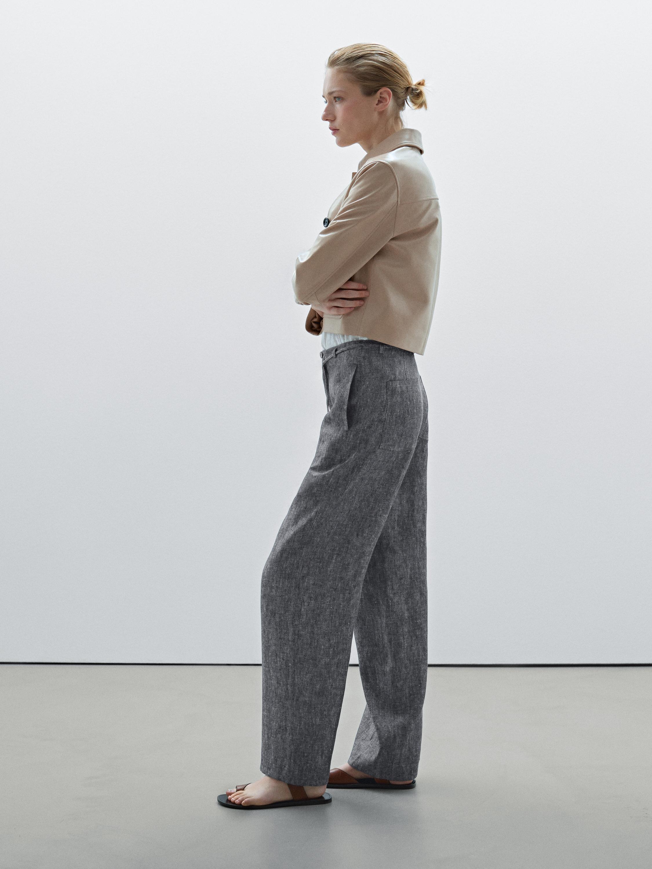 Ensemble veste beige et pantalon gris à jambes larges.