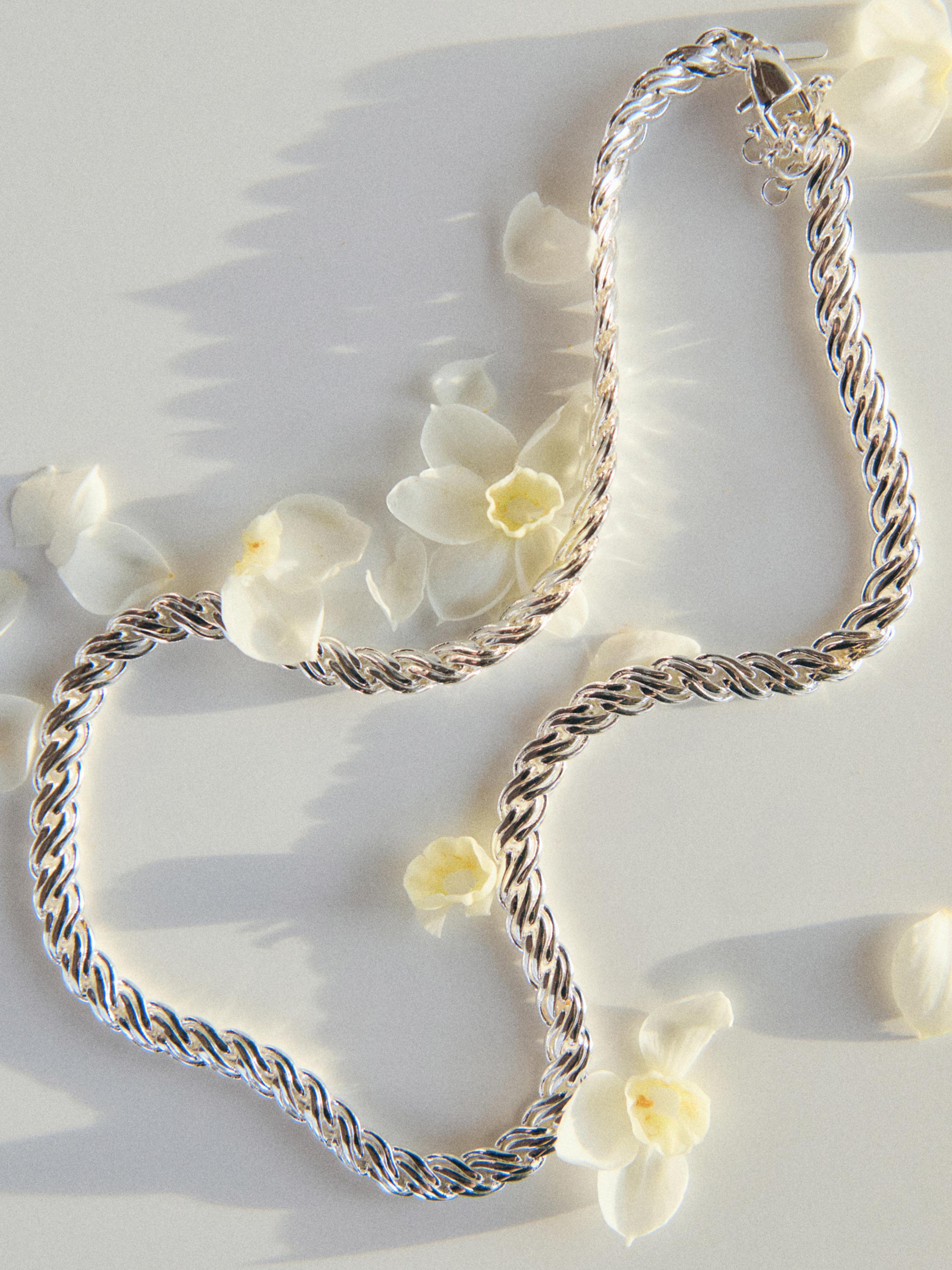 Collar de cadena trenzada en color plata con largo total de 44 cm más 5 cm de extensor.