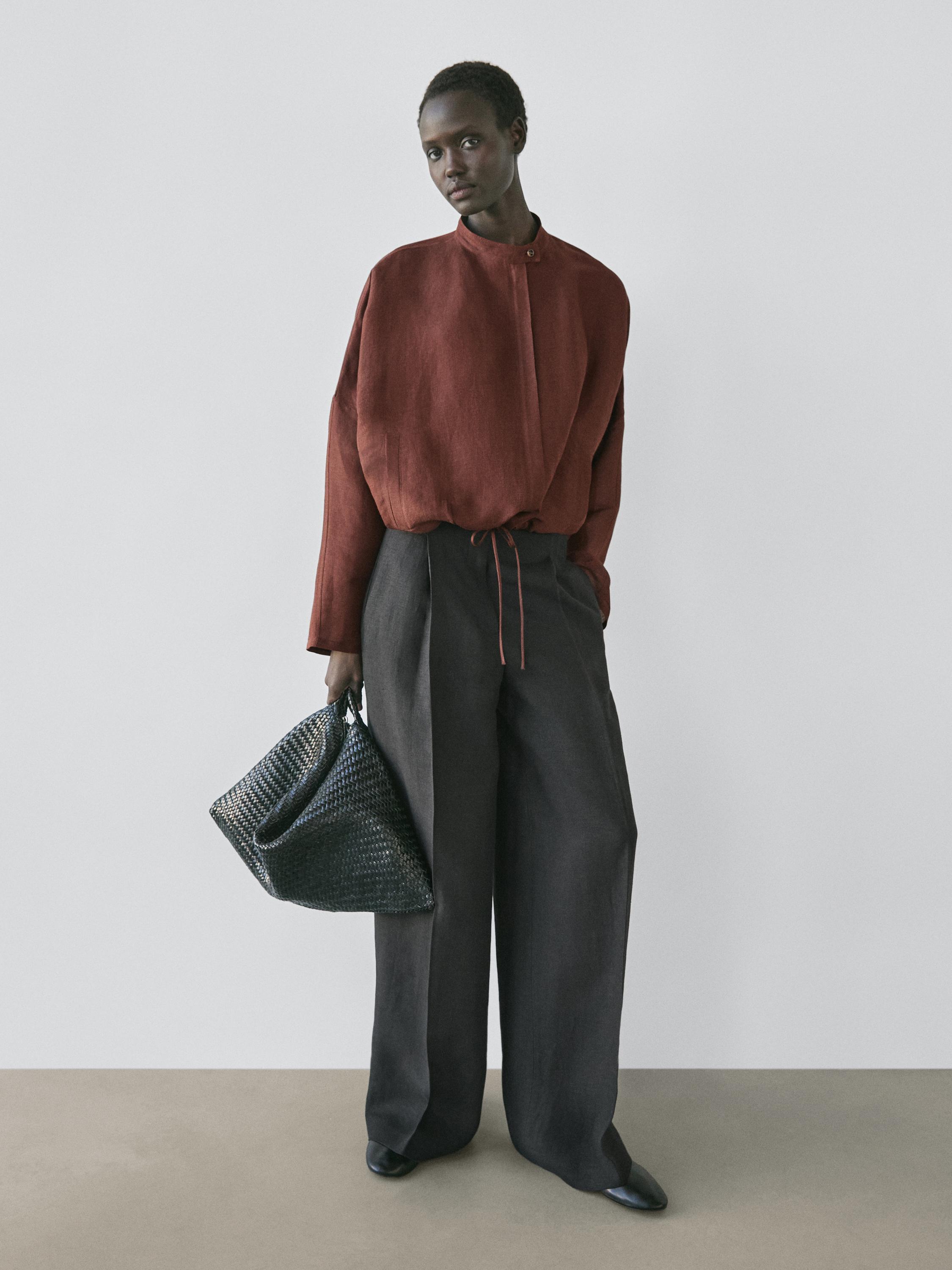 Conjunto de blusa marrón de cuello alto y pantalón negro de pierna ancha.